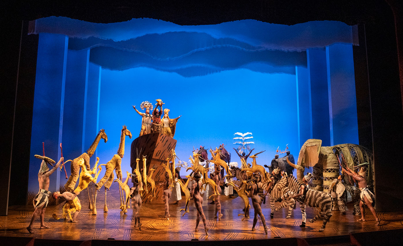 Cast members of The Lion King perform on stage.