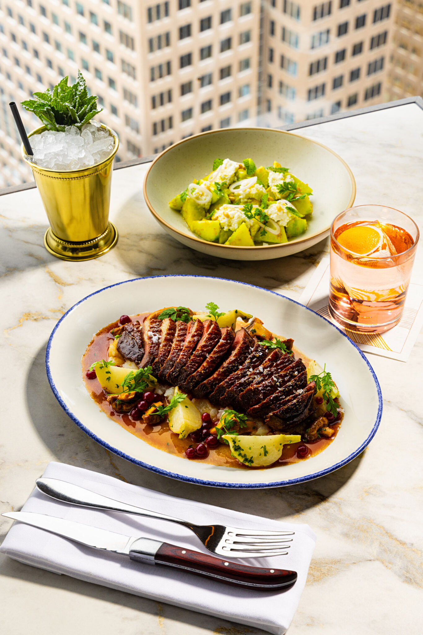 Roasted duck breast with wild mushrooms, lingonberry and smoked jus; cucumber salad; Hot Pants cocktail in a gold cup; and Blazing Sevens cocktail.