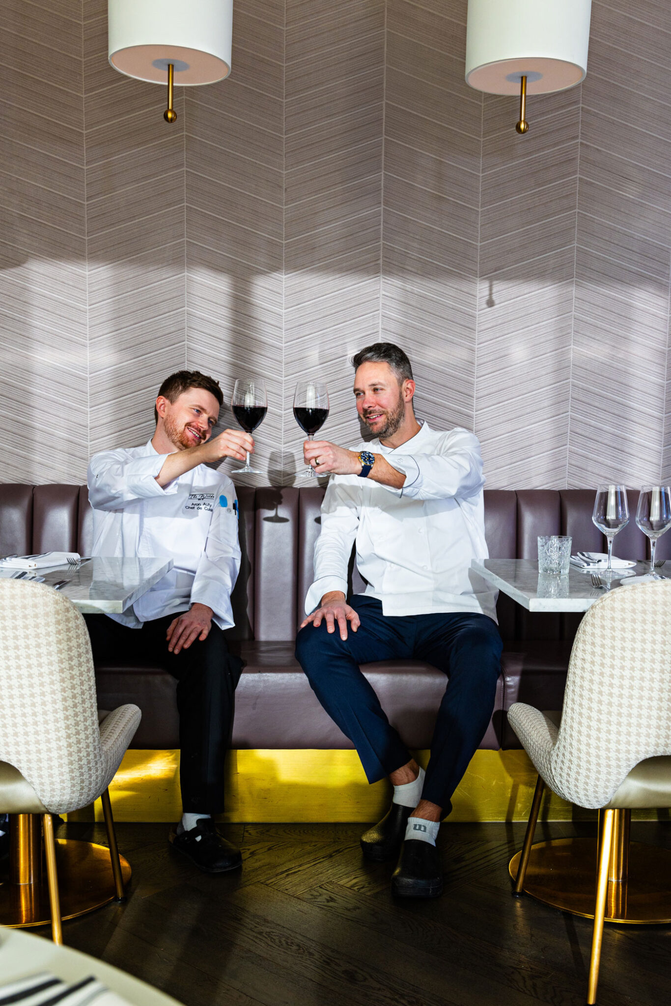 Chefs Aron Auty and Josh Dyer share a glass of wine.