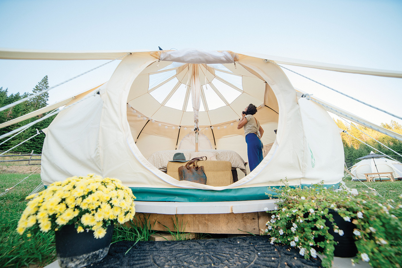 A person stands inside a glamping tent.