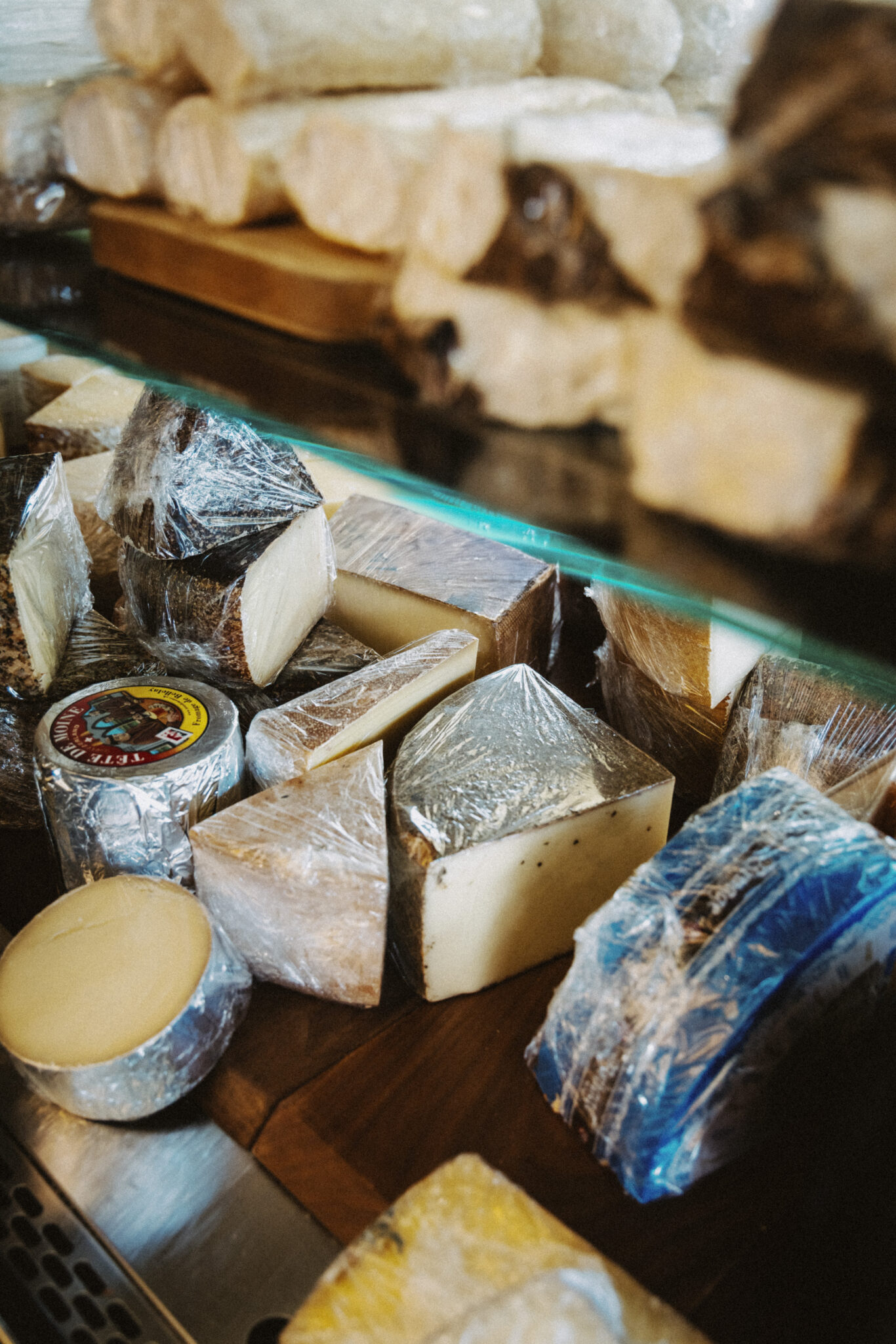 A glass case filled with a variety of cheese at Peasant Cheese in Calgary.