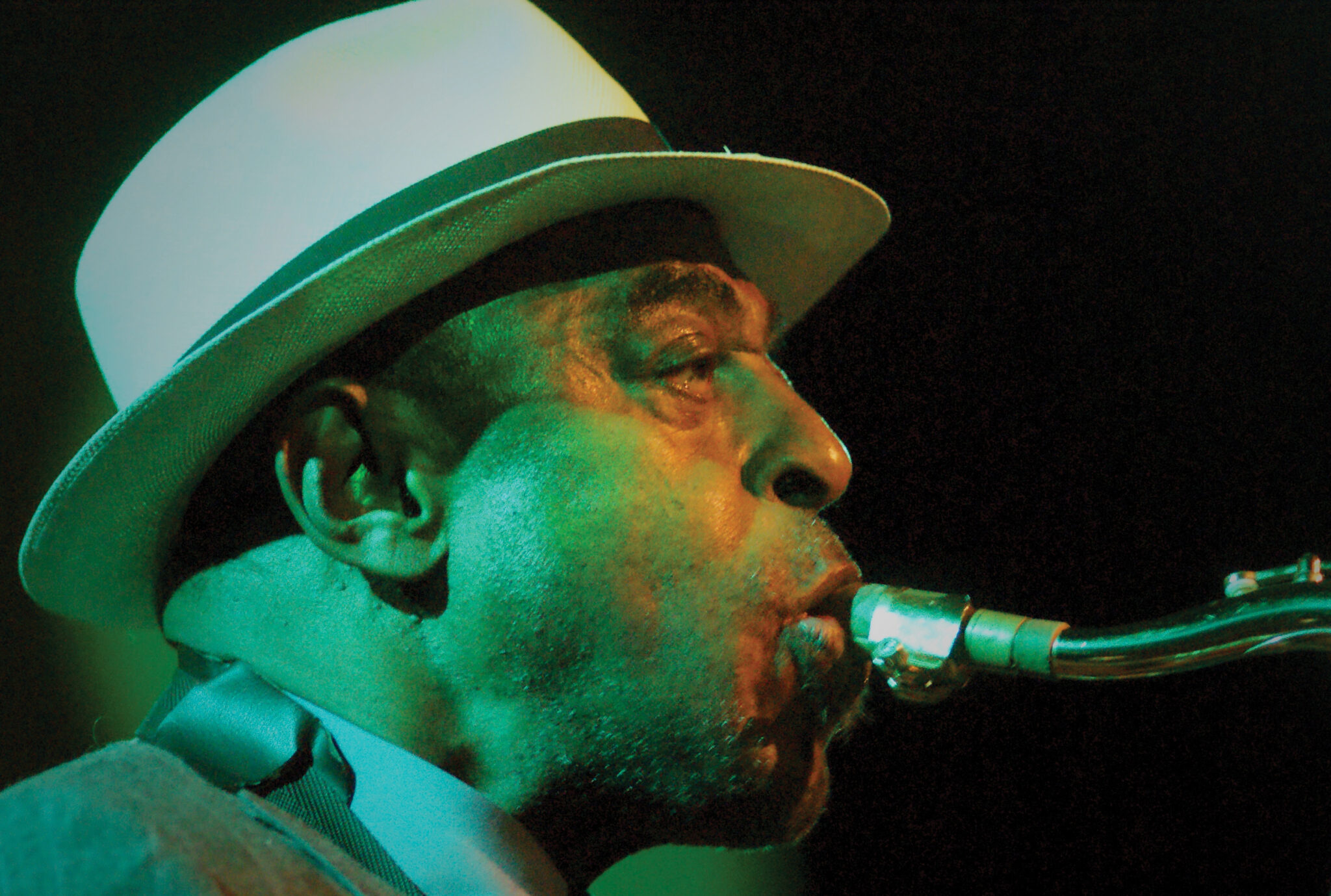 Archie Shepp wearing a hat and playing an instrument.