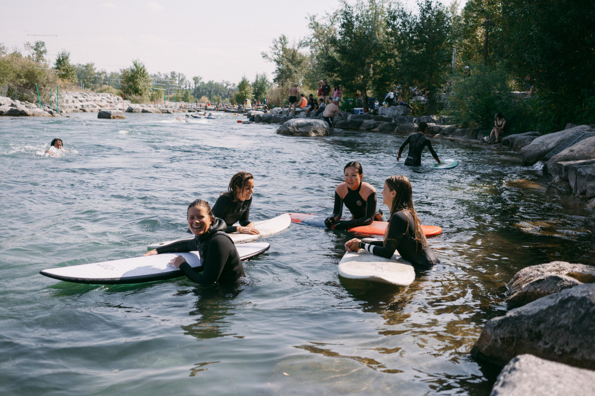 A group of friends float on the with their surfboards.