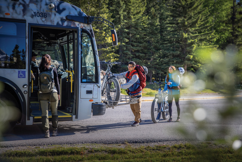 People load onto a large transit bus in Banff.