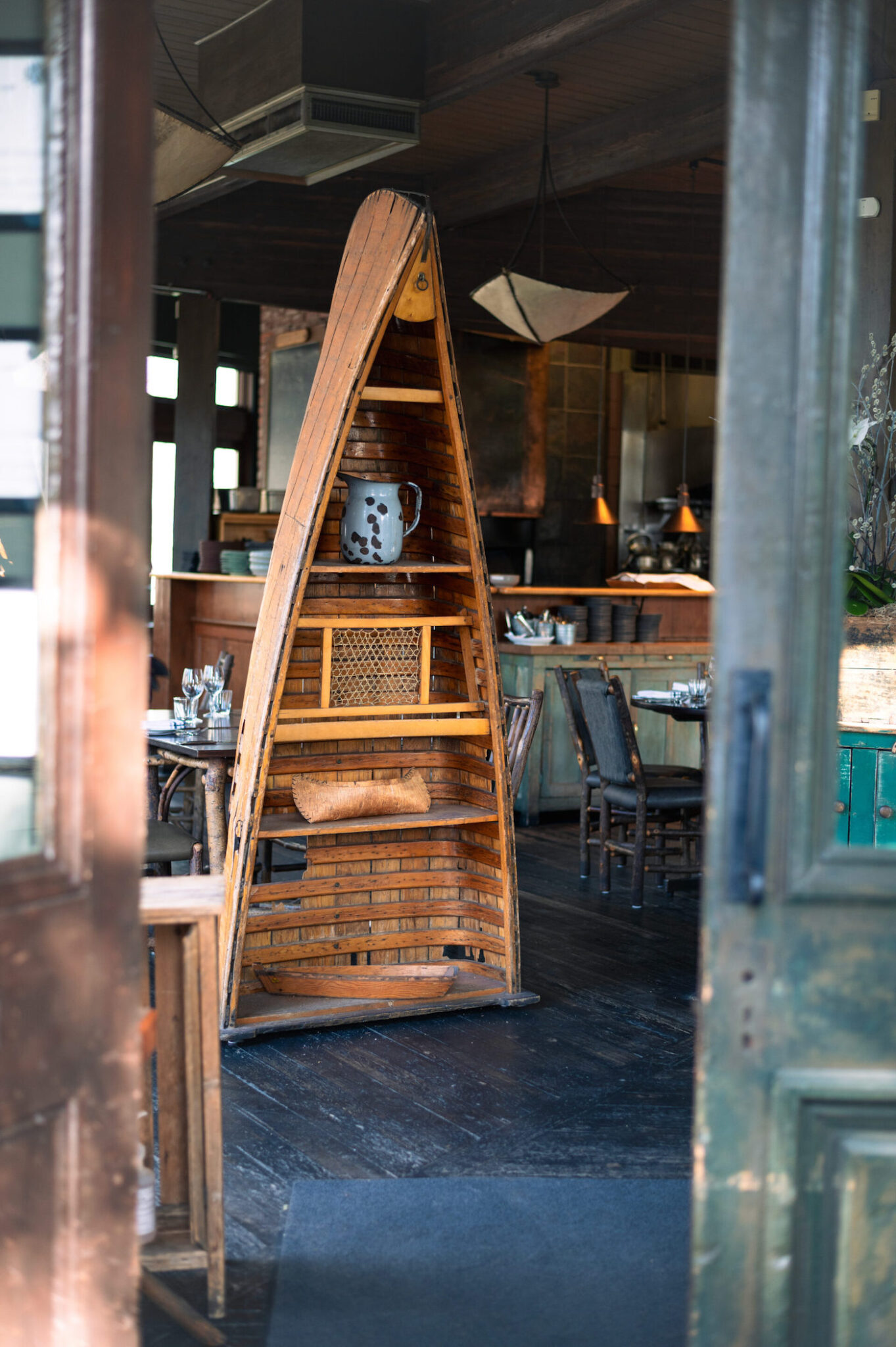 A decorative shelf made from part of a canoe inside a restaurant.