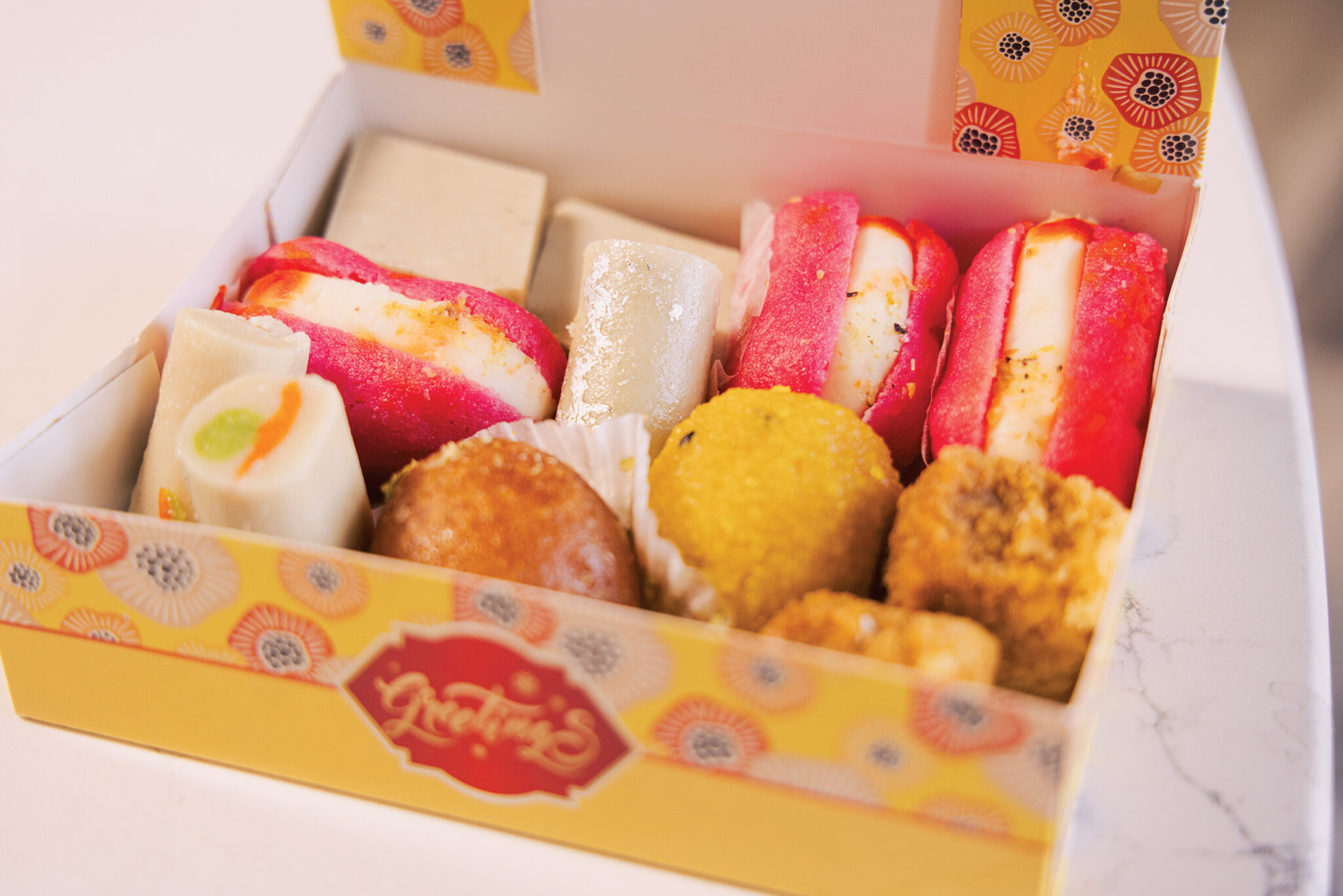 A box of sweets and baked goods in a yellow box
