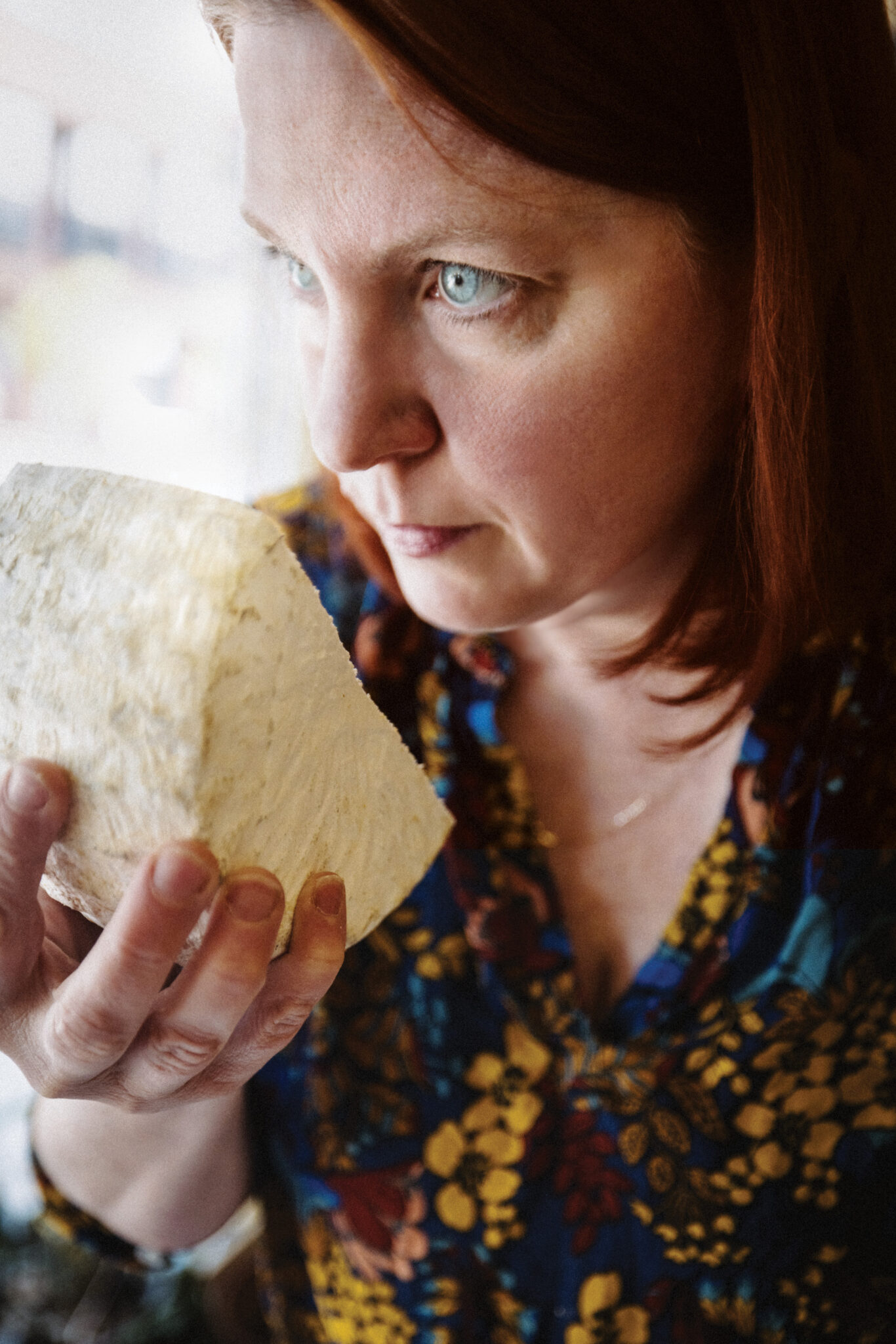 Peasant Cheese owner Crystal McKenzie sniffs a block of cheese. 