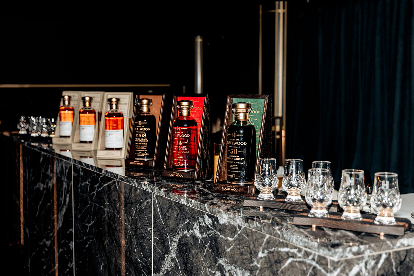 A selection of whiskeys and glasses on a counter