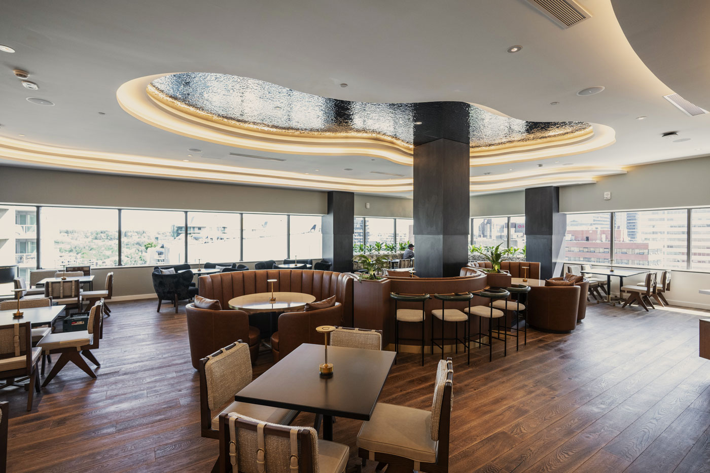 A restaurant interior with tables, chairs and brown booth seating
