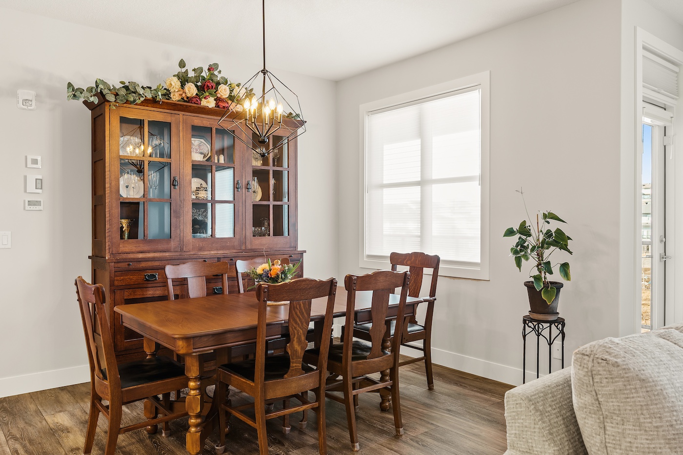 A dining area with a table, chairs and cabinet