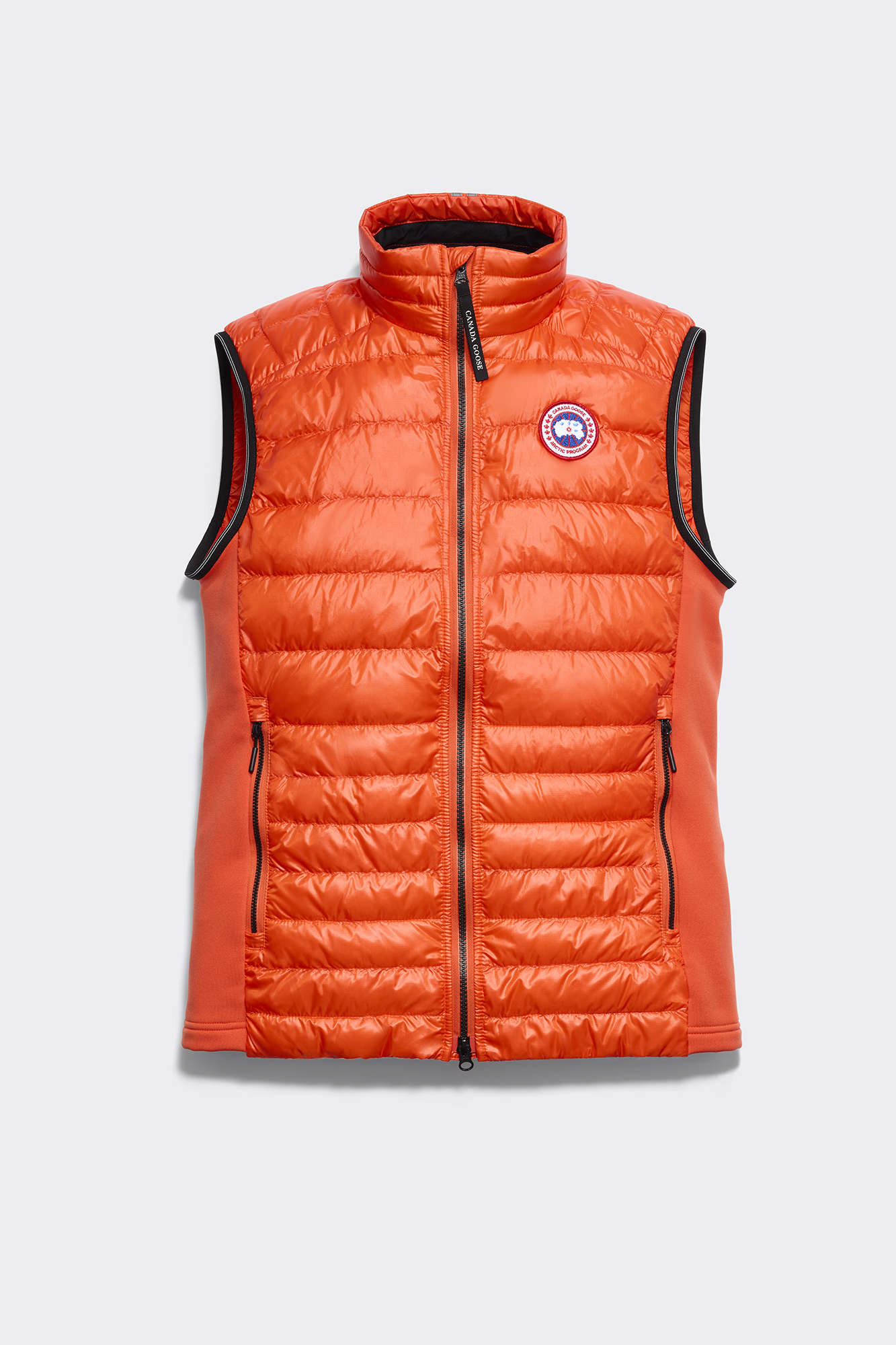 An orange puffer vest in front of a white background.
