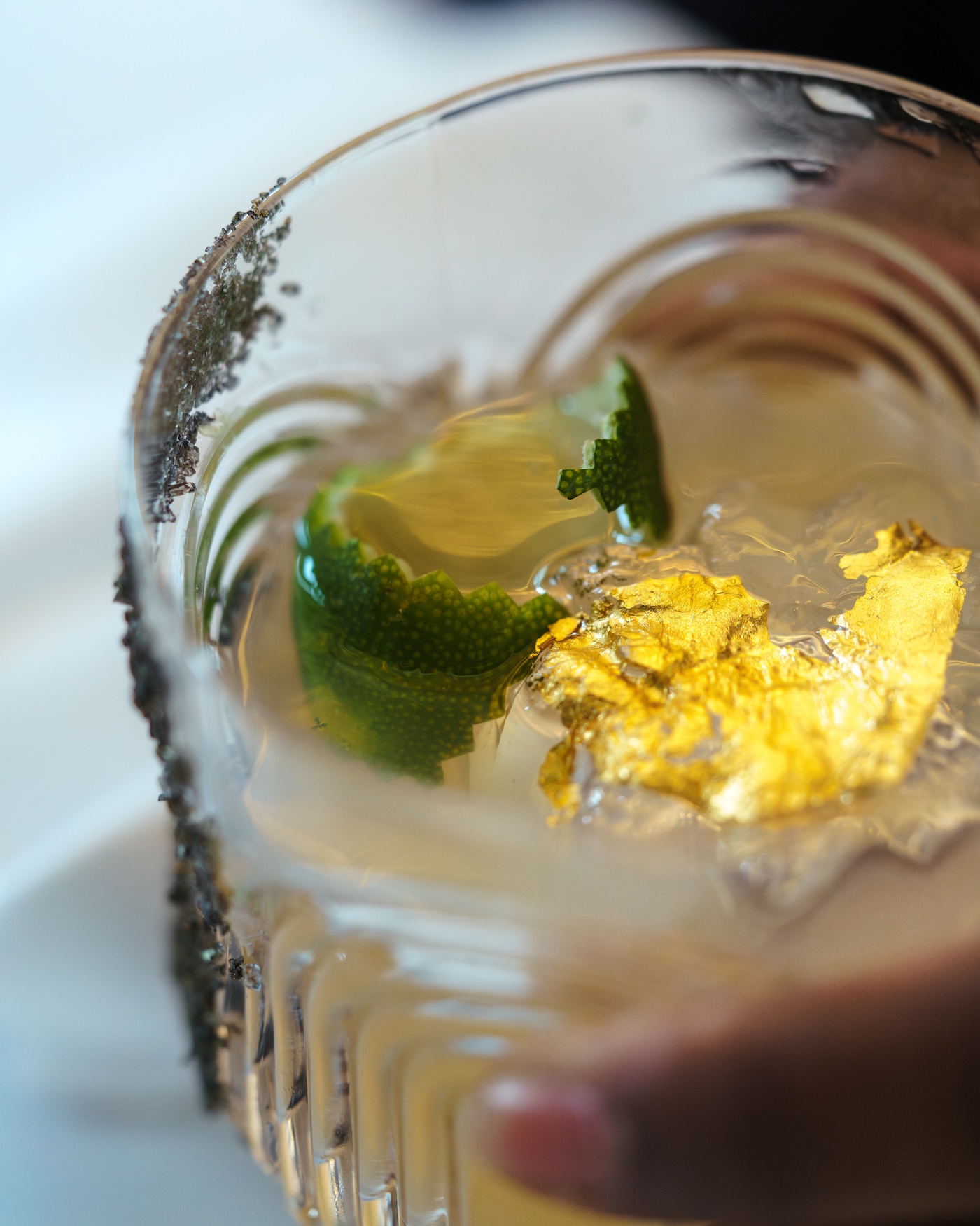 A close-up photo of a hand holding a cocktail