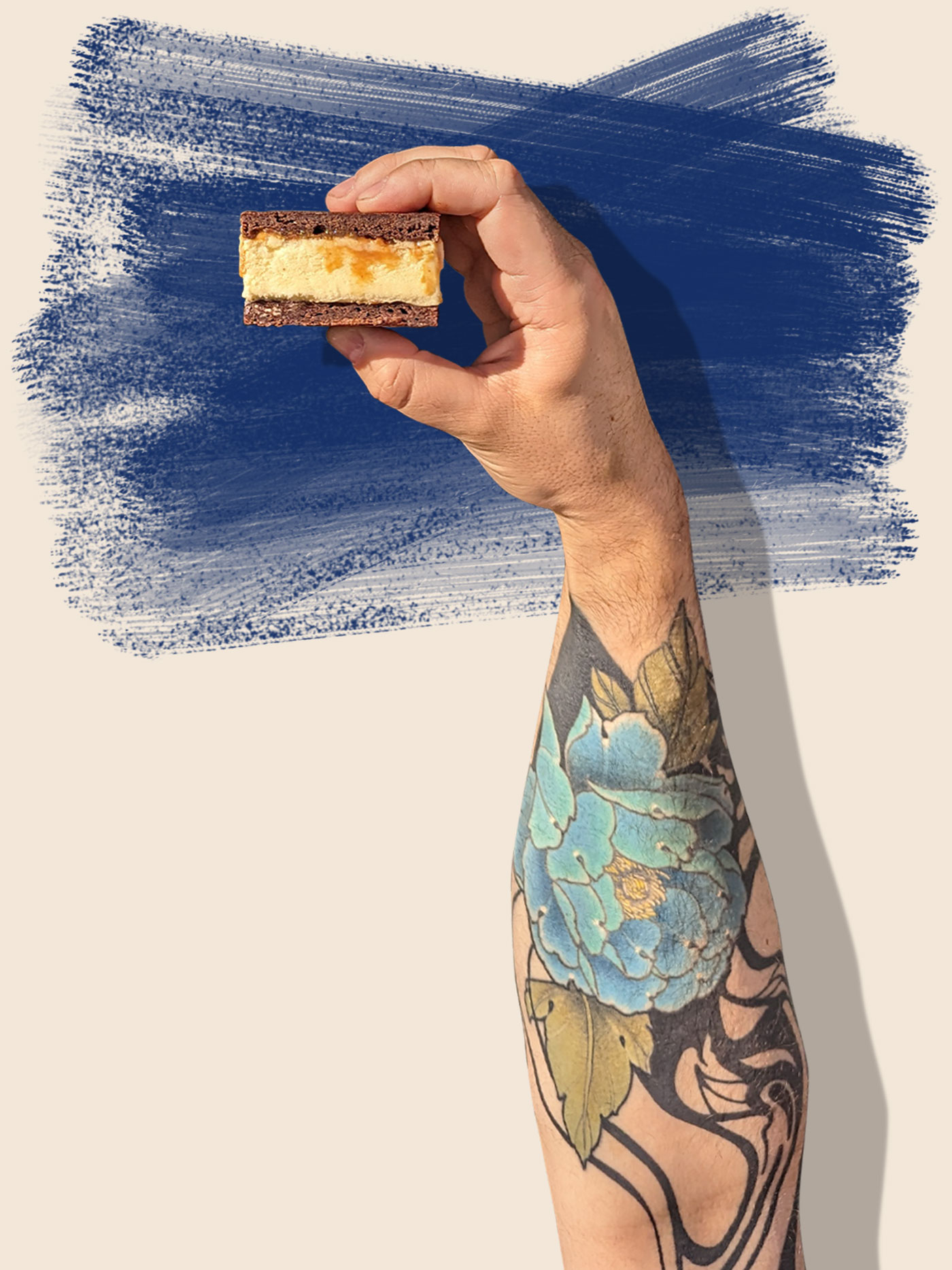 A hand holds an ice cream sandwich over a blue background.