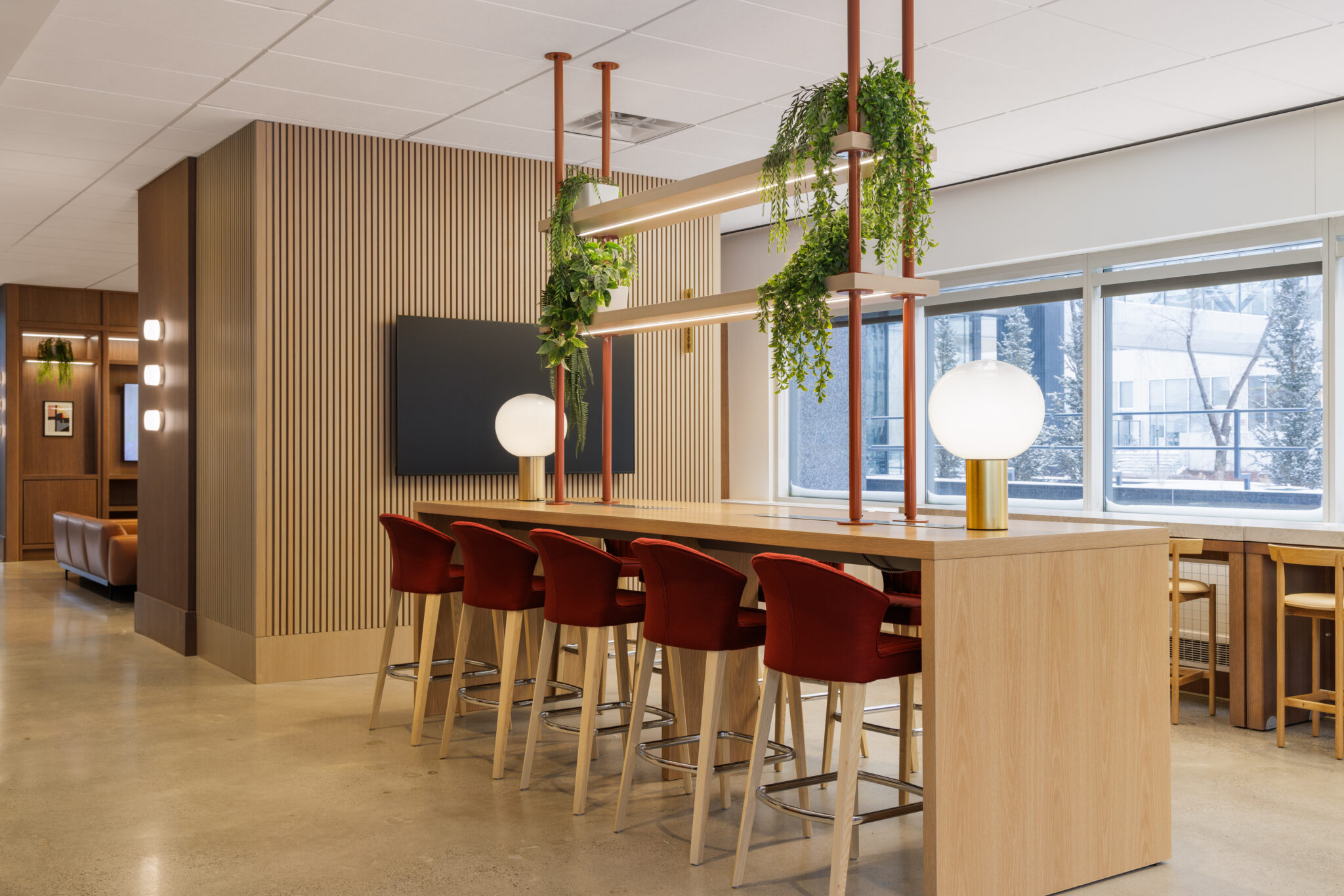 A common area inside a commercial building with an island for seating that looks out a window.