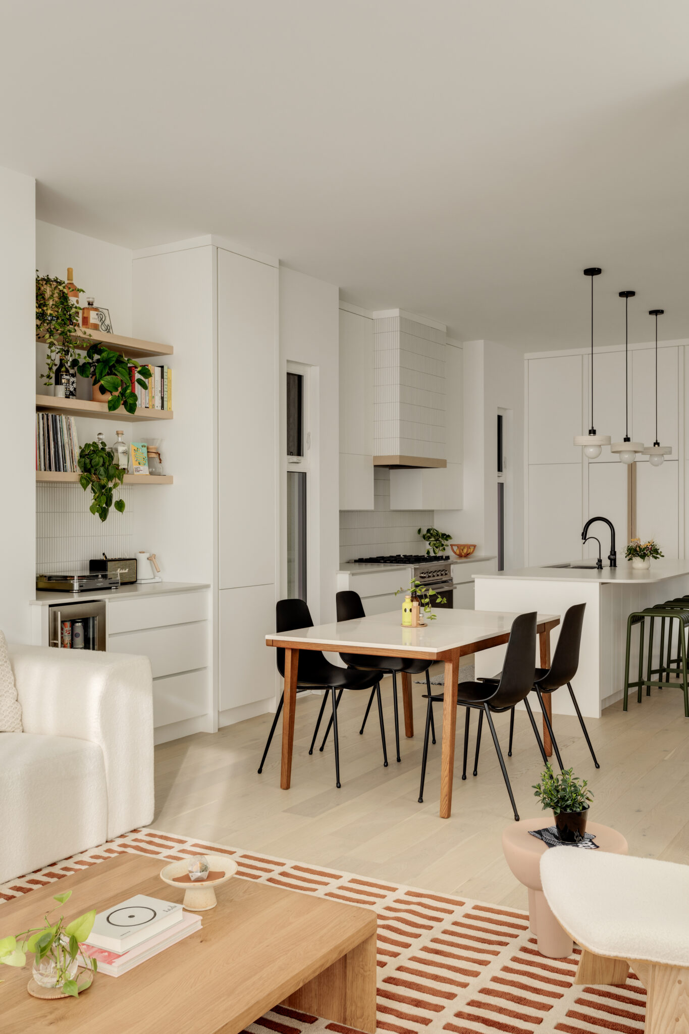 A home kitchen with a four-person dining table, an island, a stove and a bar nook.