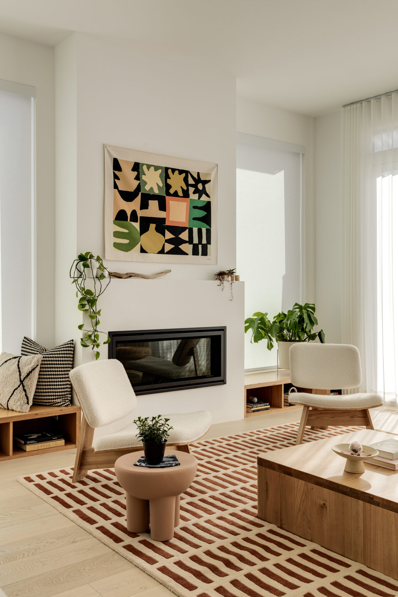 A living room with artwork above a white fireplace 