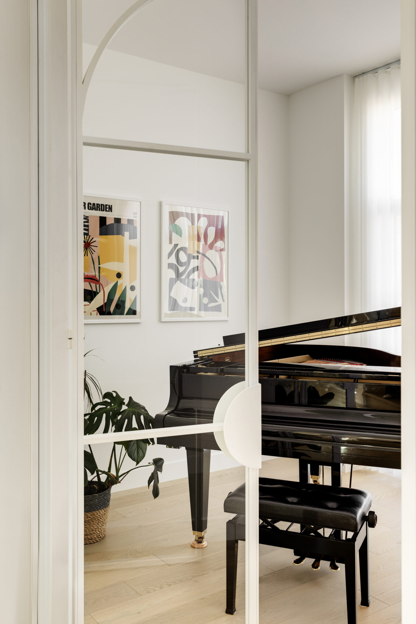 A black piano pictured behind glass doors