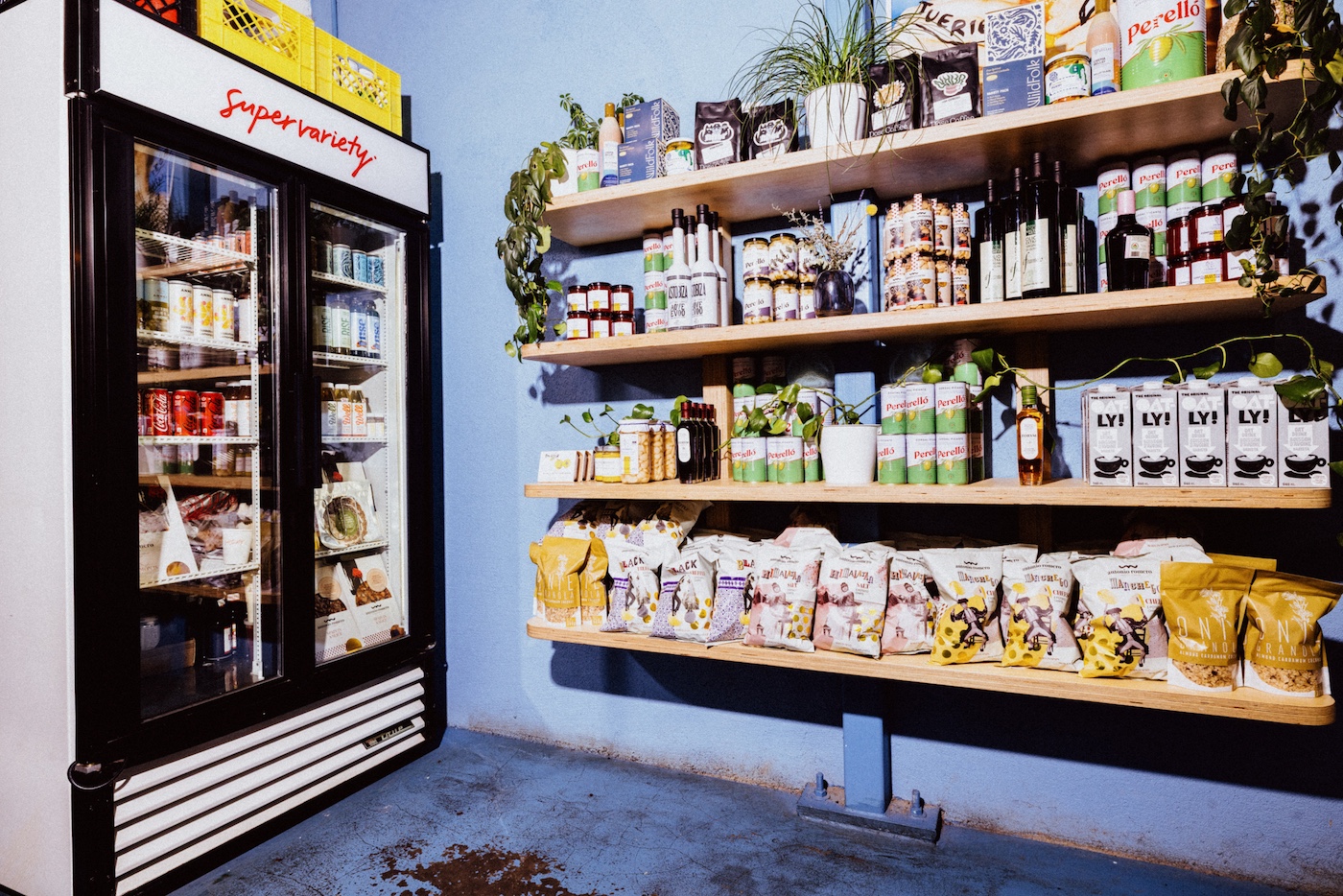 Shelves and a fridge filled with packaged food products in Super Variety