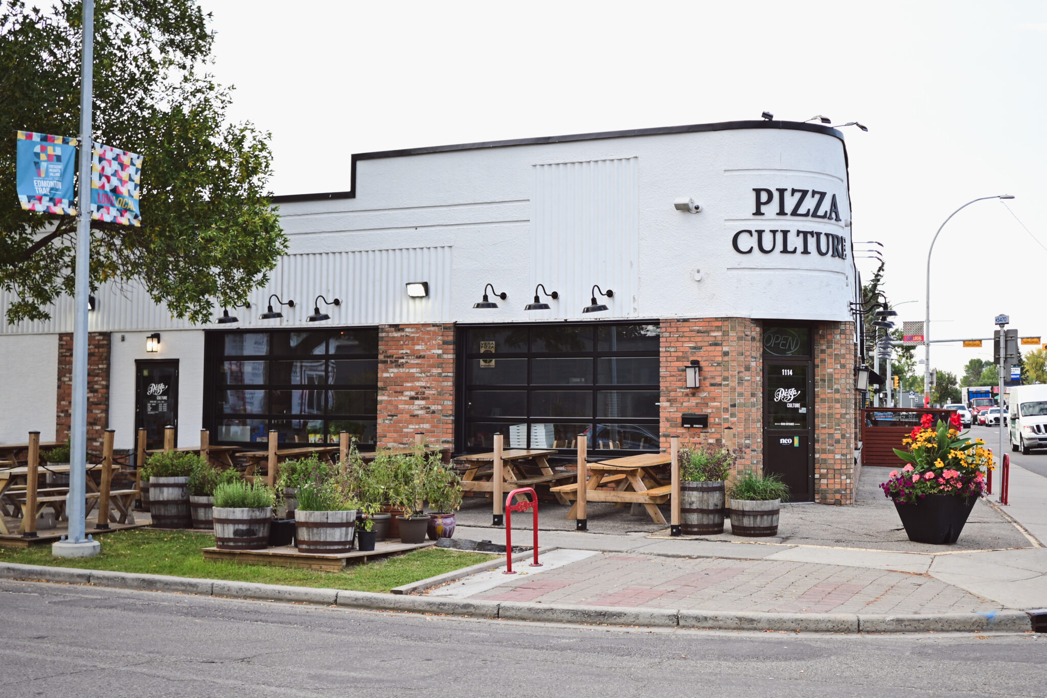 A pizzeria with a white and brick exterior.