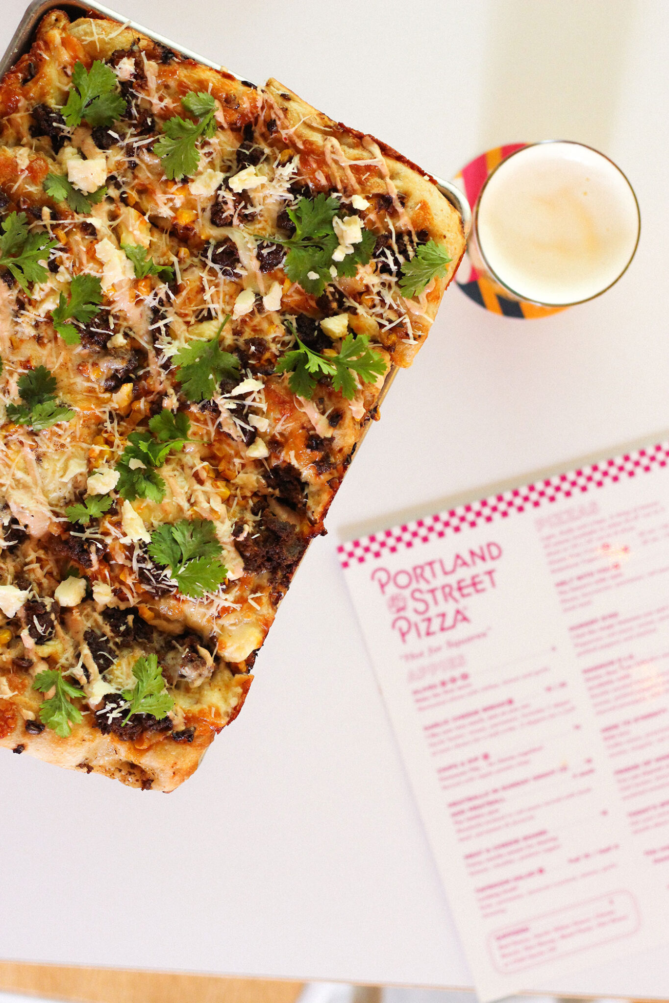 A pizza and a beer on a table