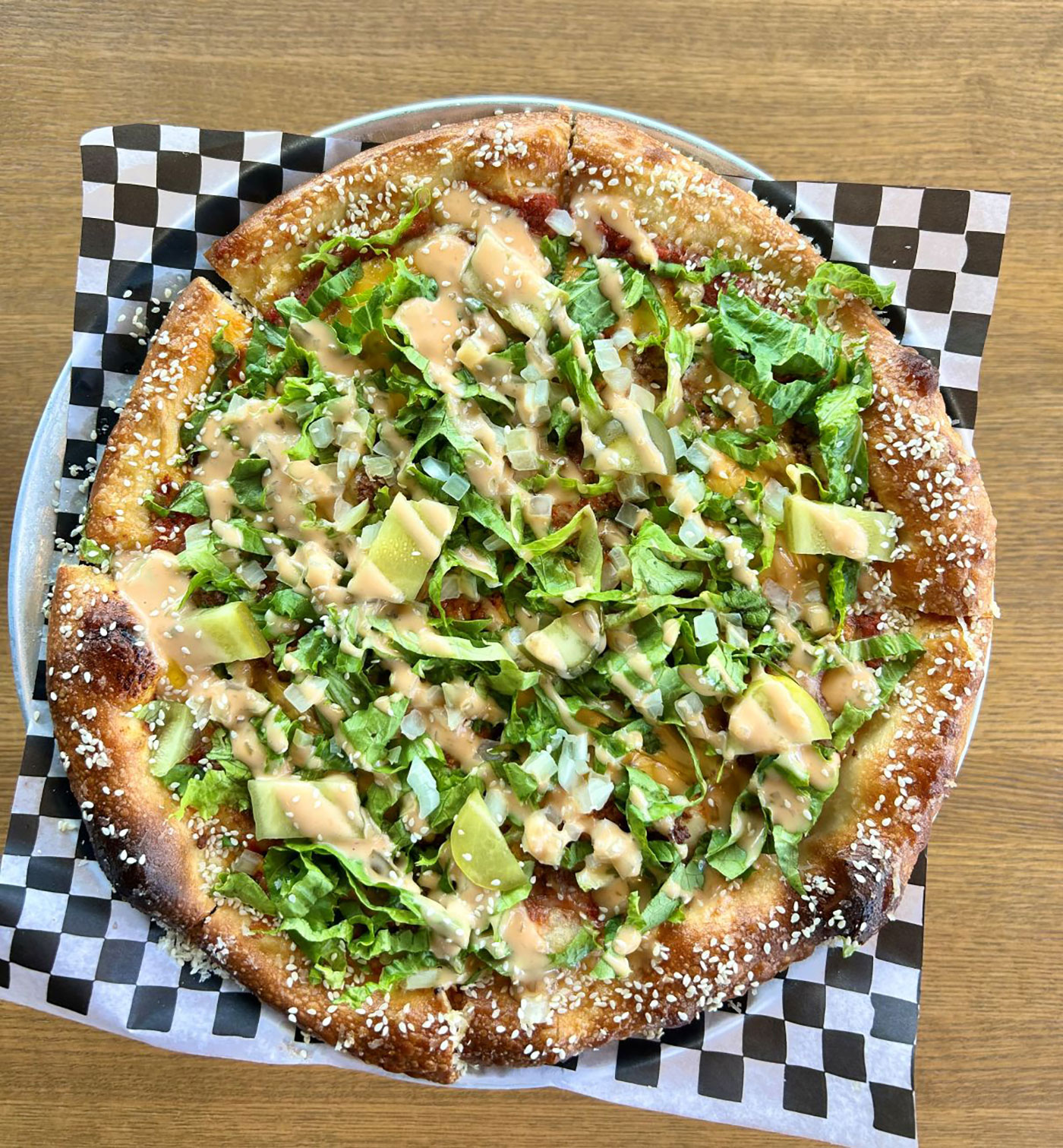 A pizza sitting on top of a plate with a checkered sheet