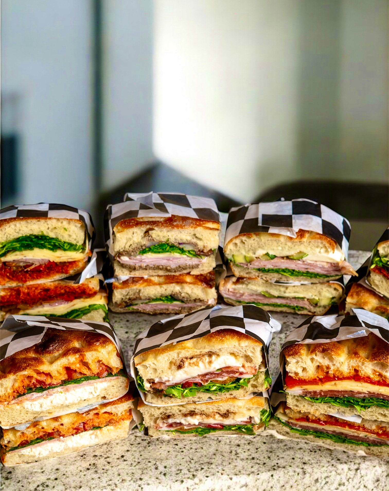 A variety of sandwiches sit on a table.