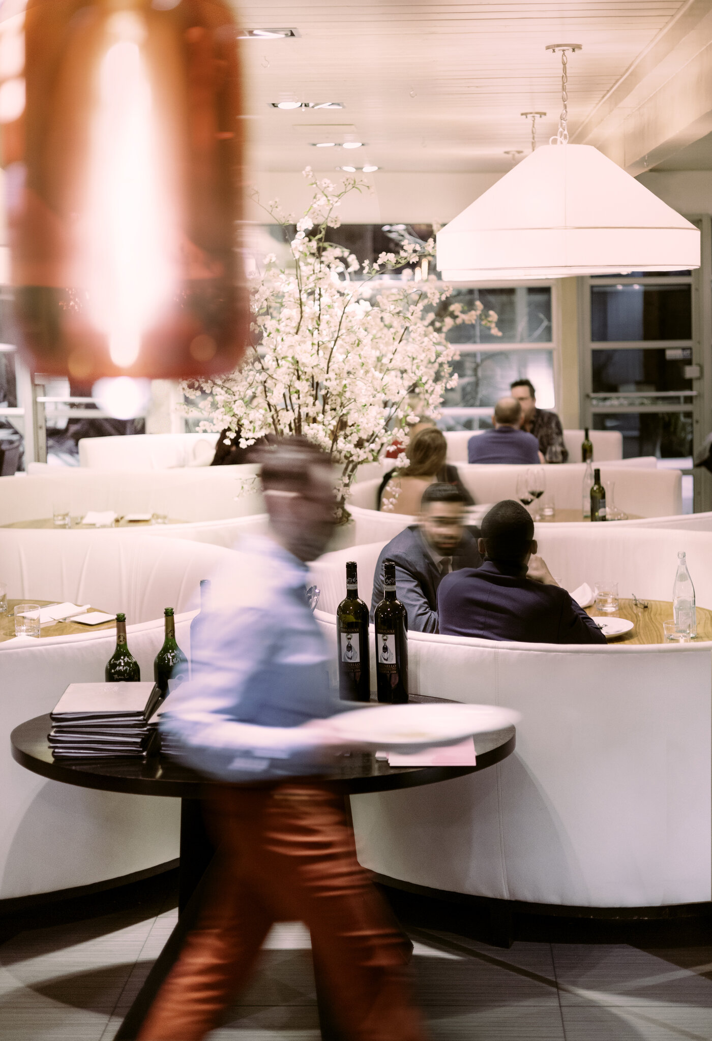 A server walks through a restaurant dining room.