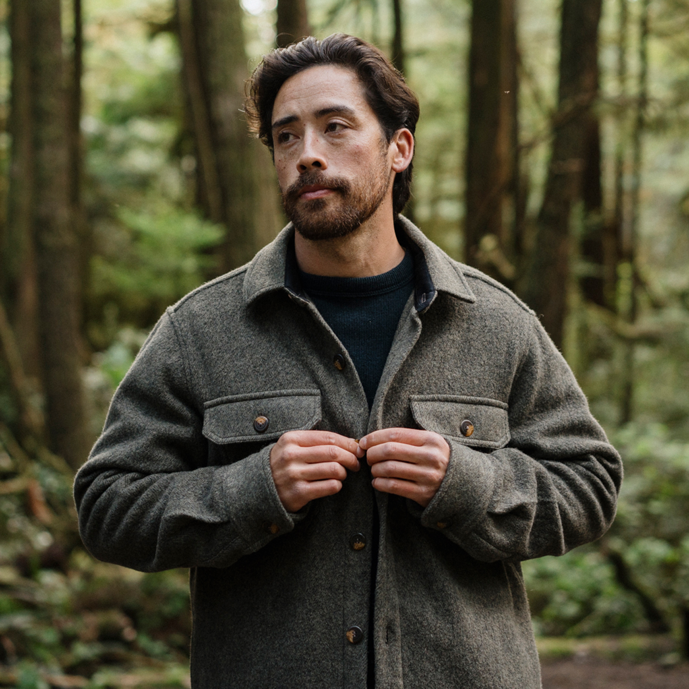 A man wearing a coat in the forest