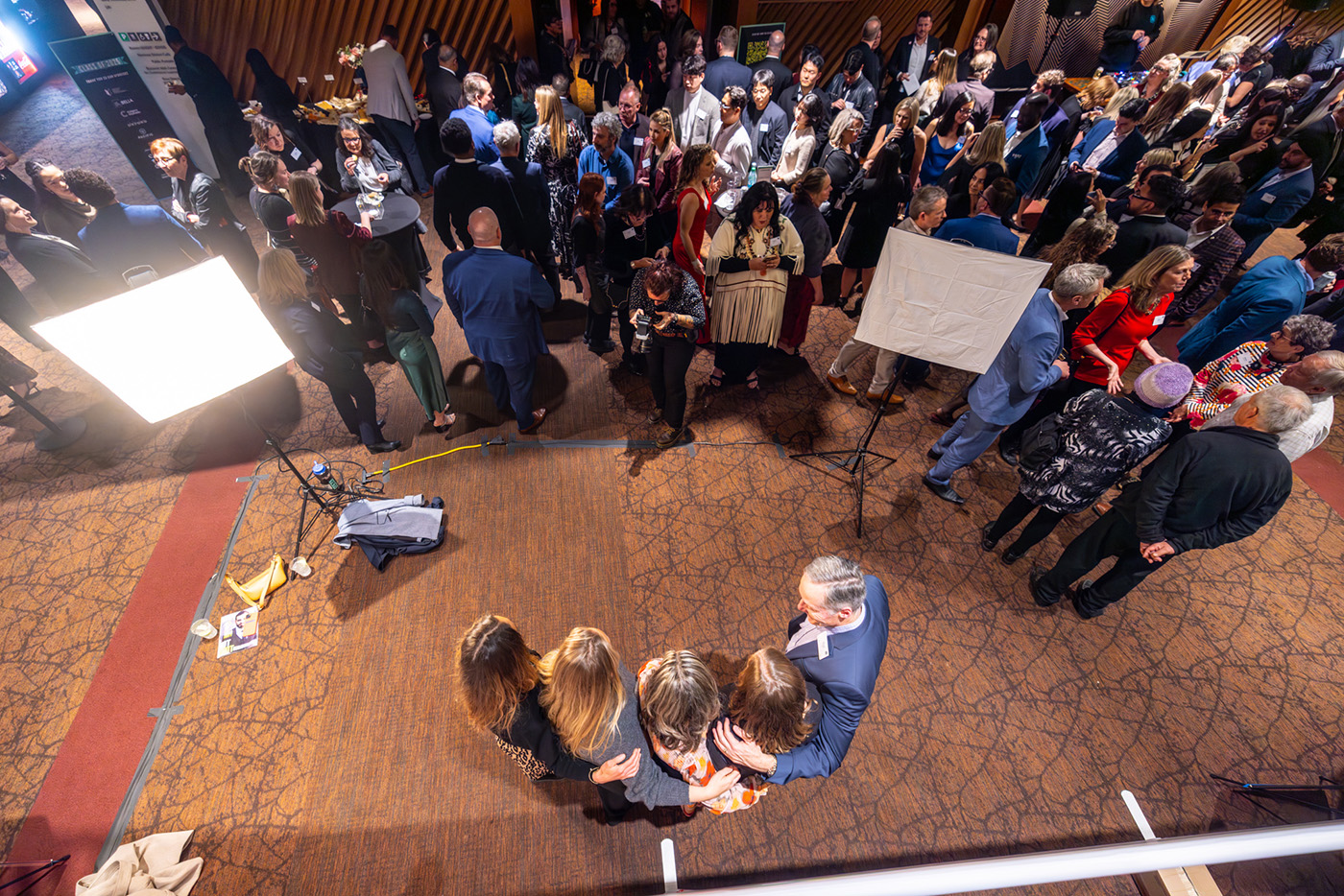 People pose for photos at a photo wall