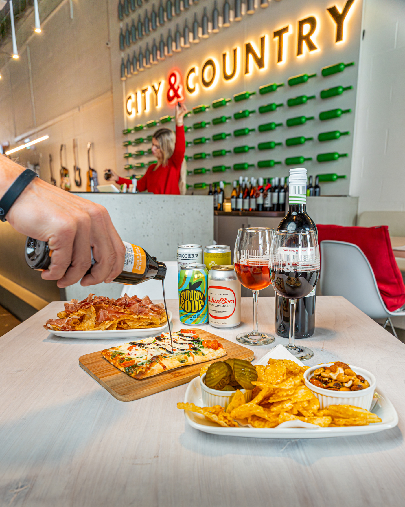 A table full of food, wine and other drinks in a winery and tasting room
