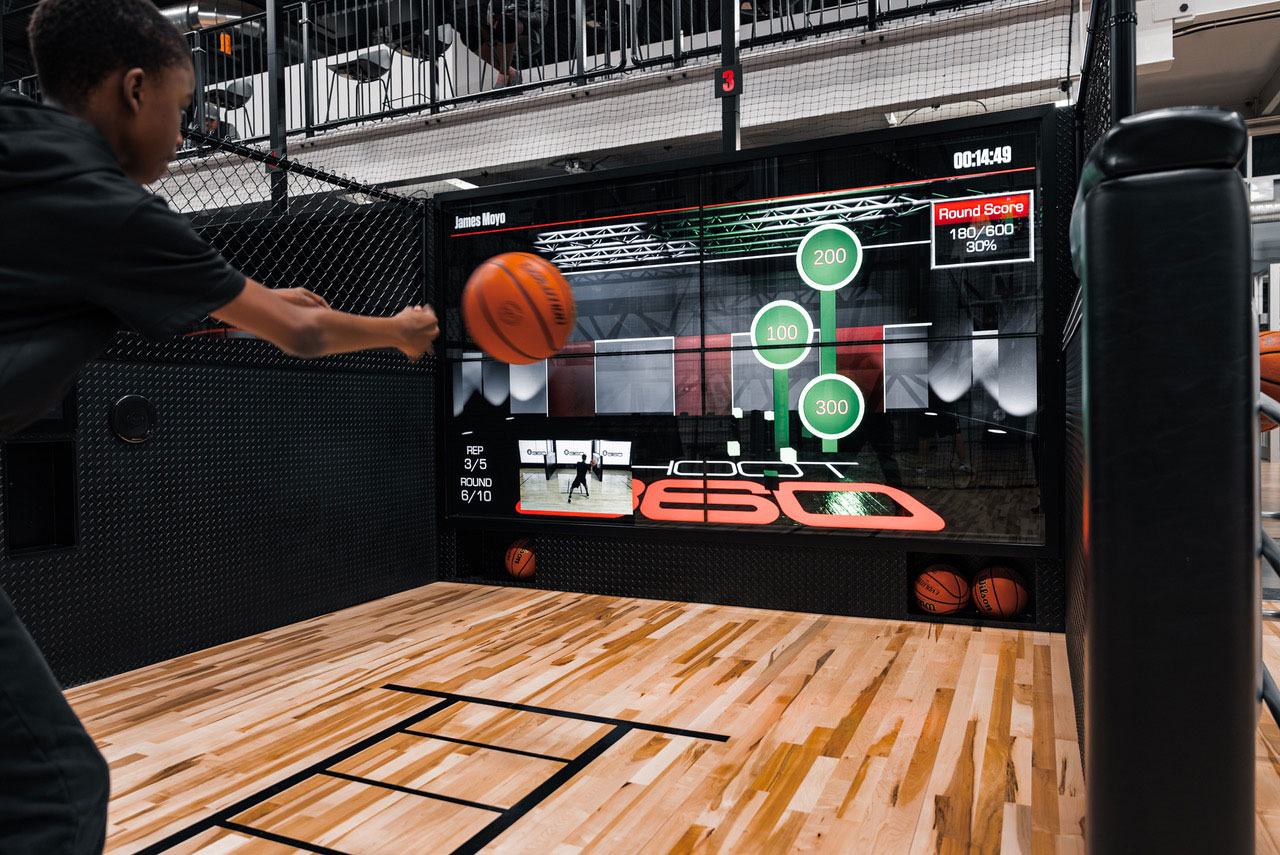 A basketball player throws a basketball in a basketball facility.