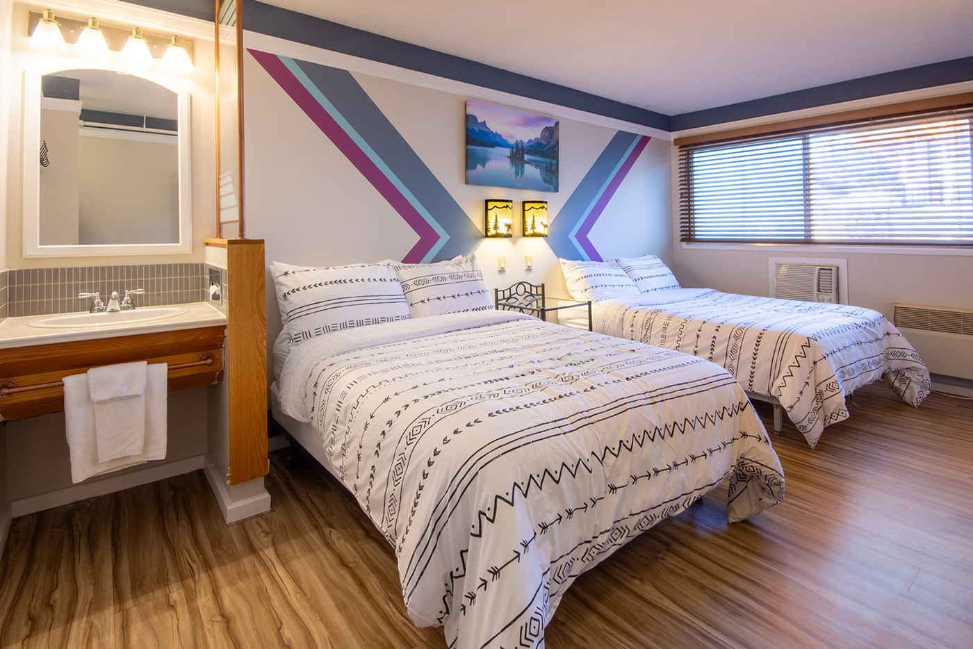 A hotel room with two beds and a sink