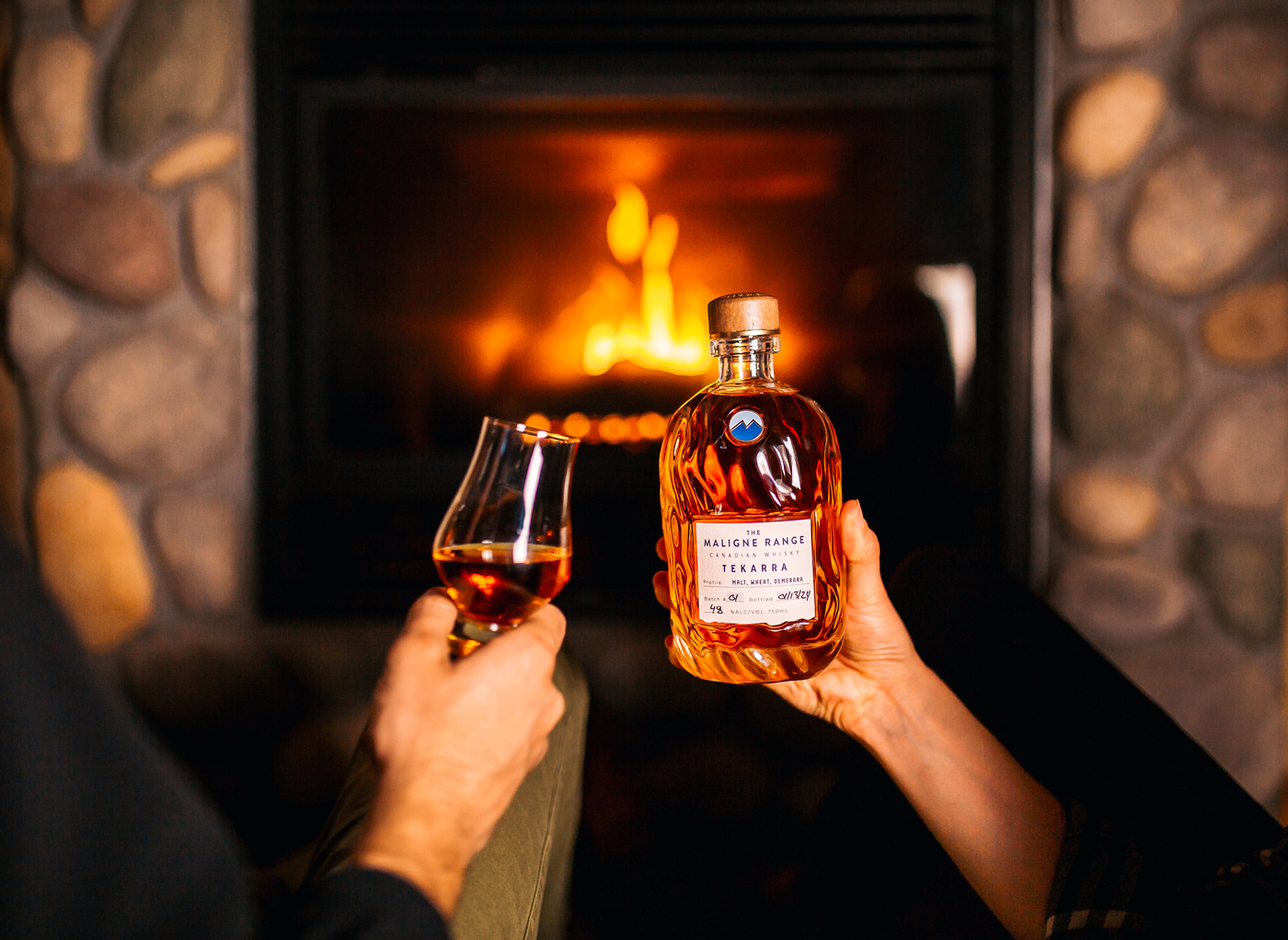 Two handles hold a bottle and glass of whiskey