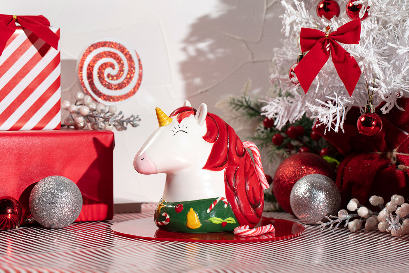 A cocktail in a unicorn mug surrounded by holiday decor
