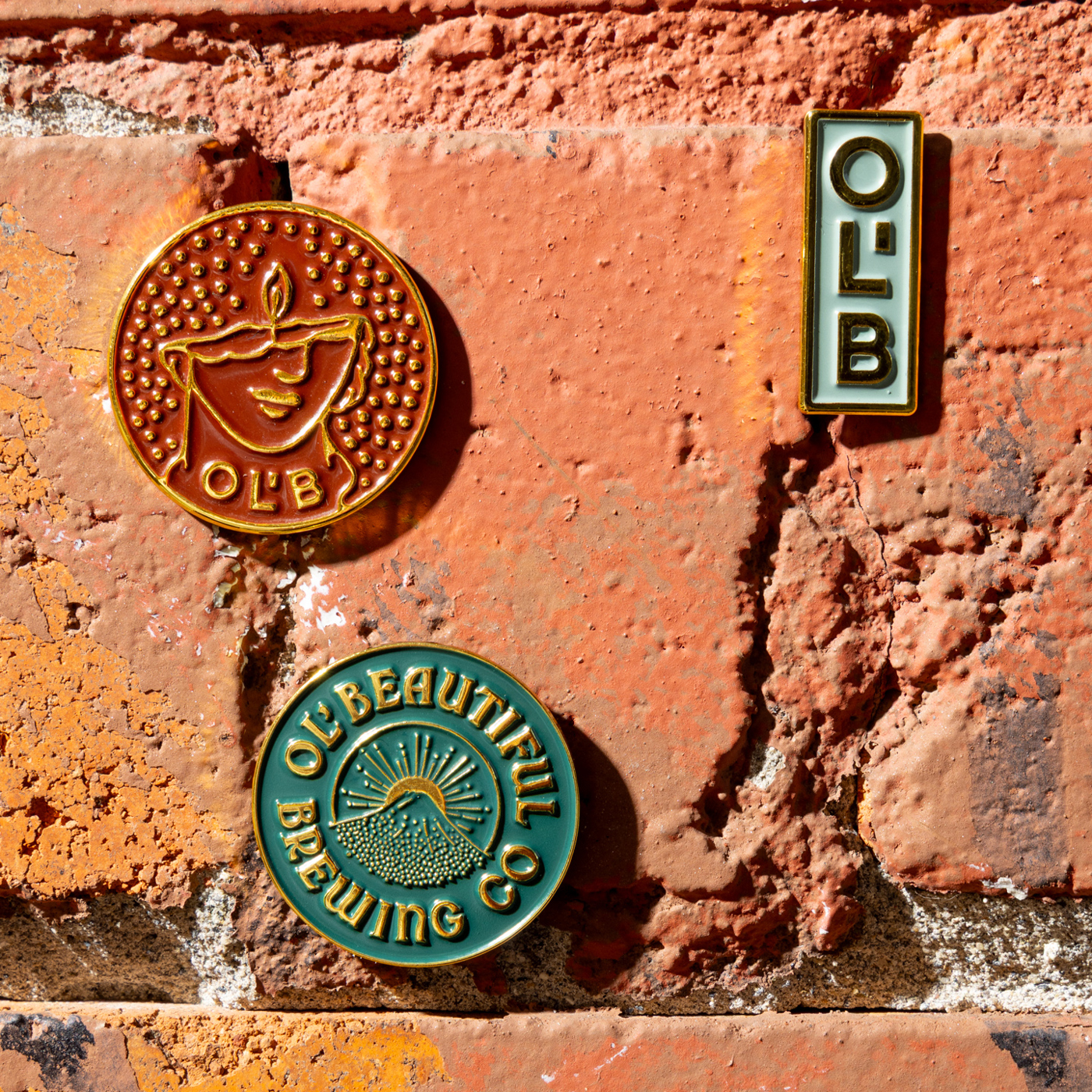 Three pins against a brick background