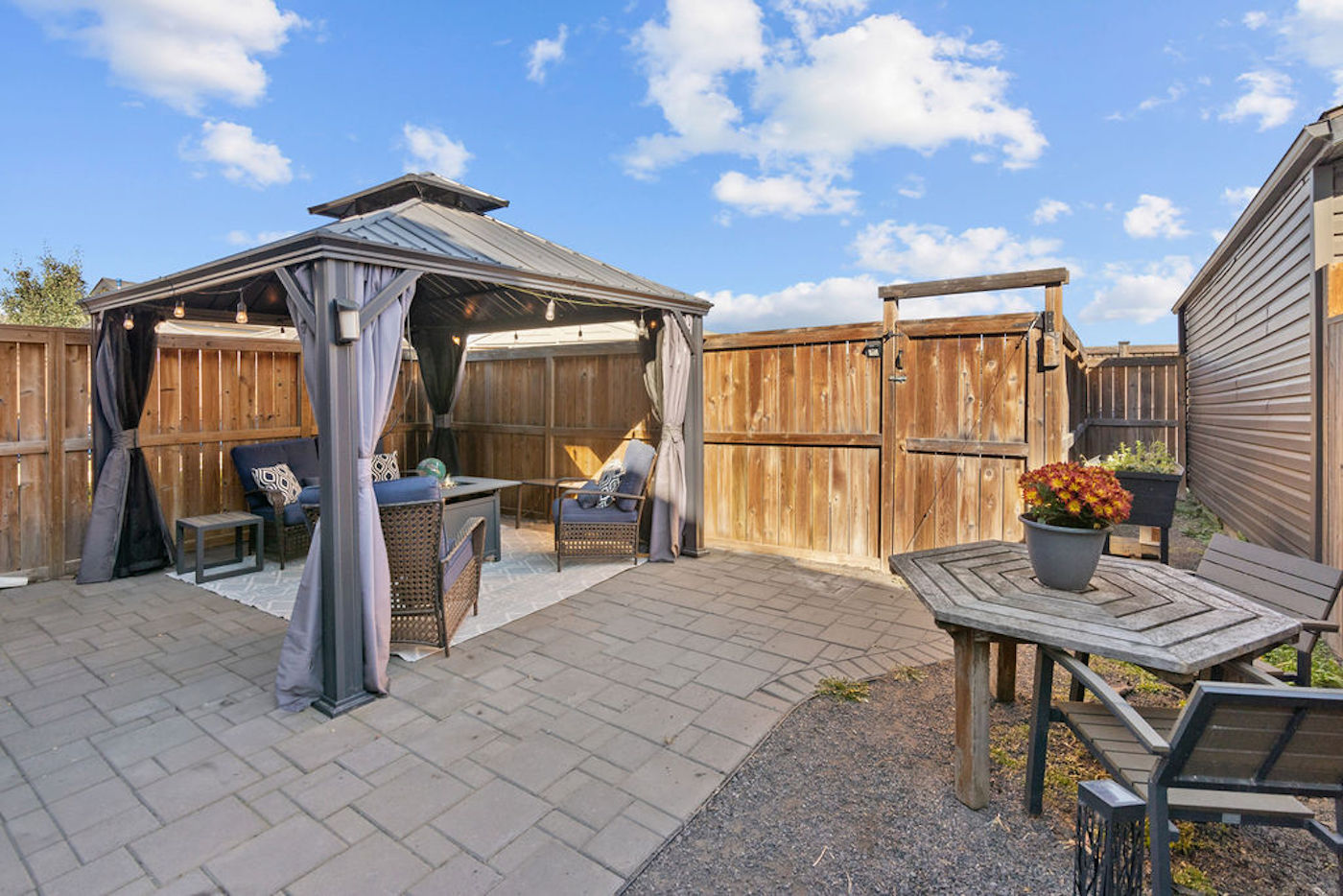 A backyard with a wooden fence and a gazebo