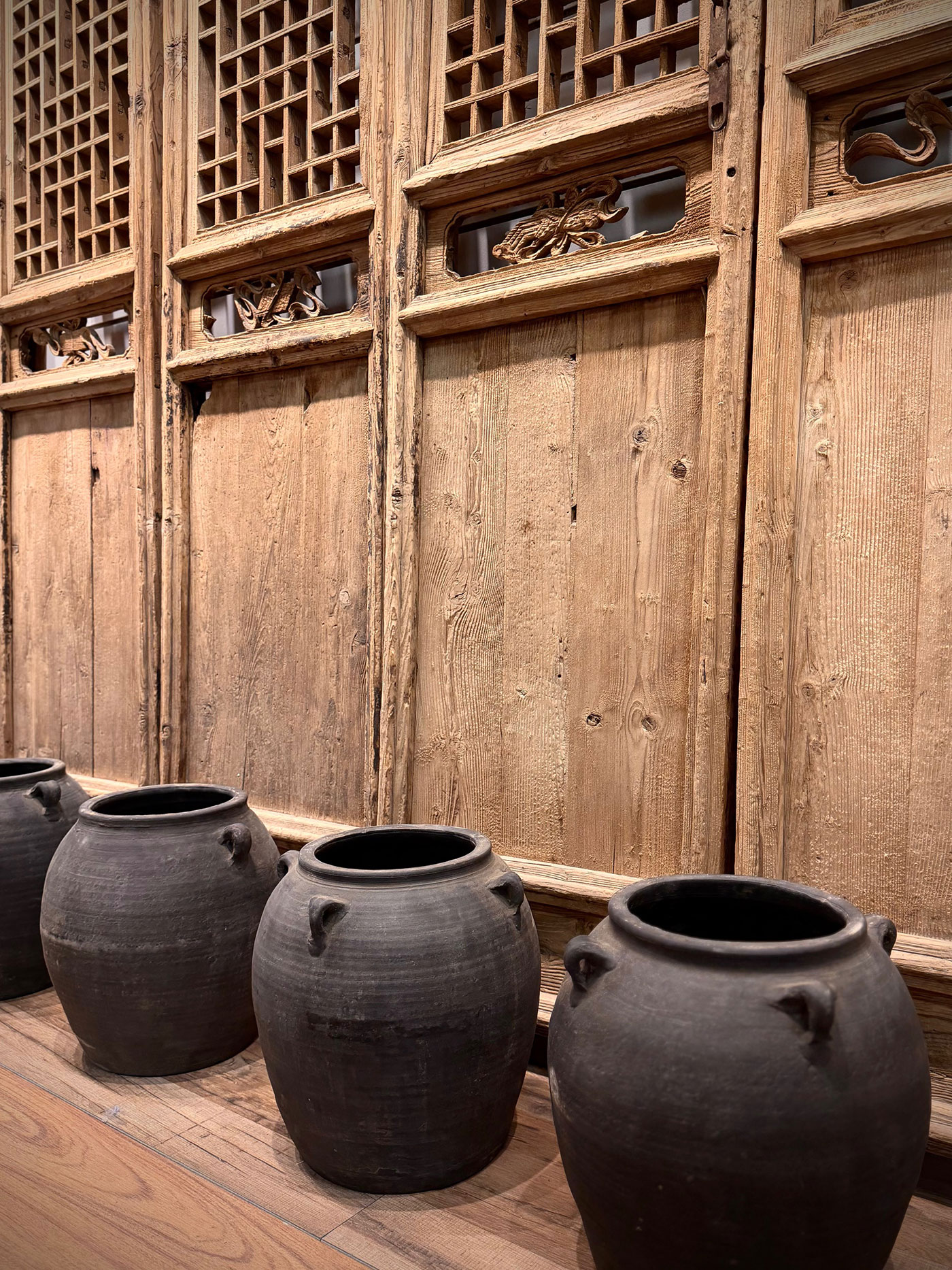 Vintage pickle pots sit on a wooden floor.