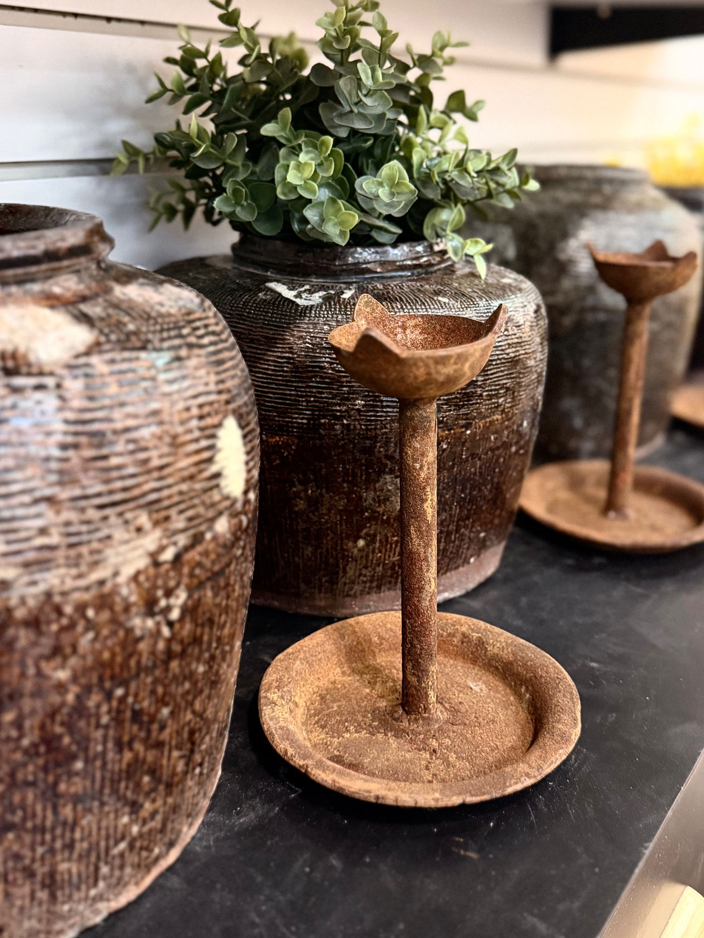 Pots and candle holders sit on a shelf.