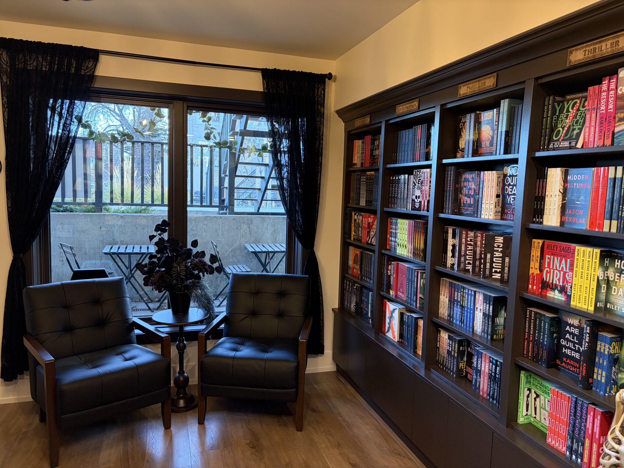 Bookstore shelves filled with books and two chairs