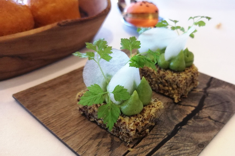 While technically not a course, the amuse bouche featured four different dishes: warm olives with fennel, a hummus-filled macaroon, carrot “brioche” buns, and this play on avocado toast on a flax seed cracker.