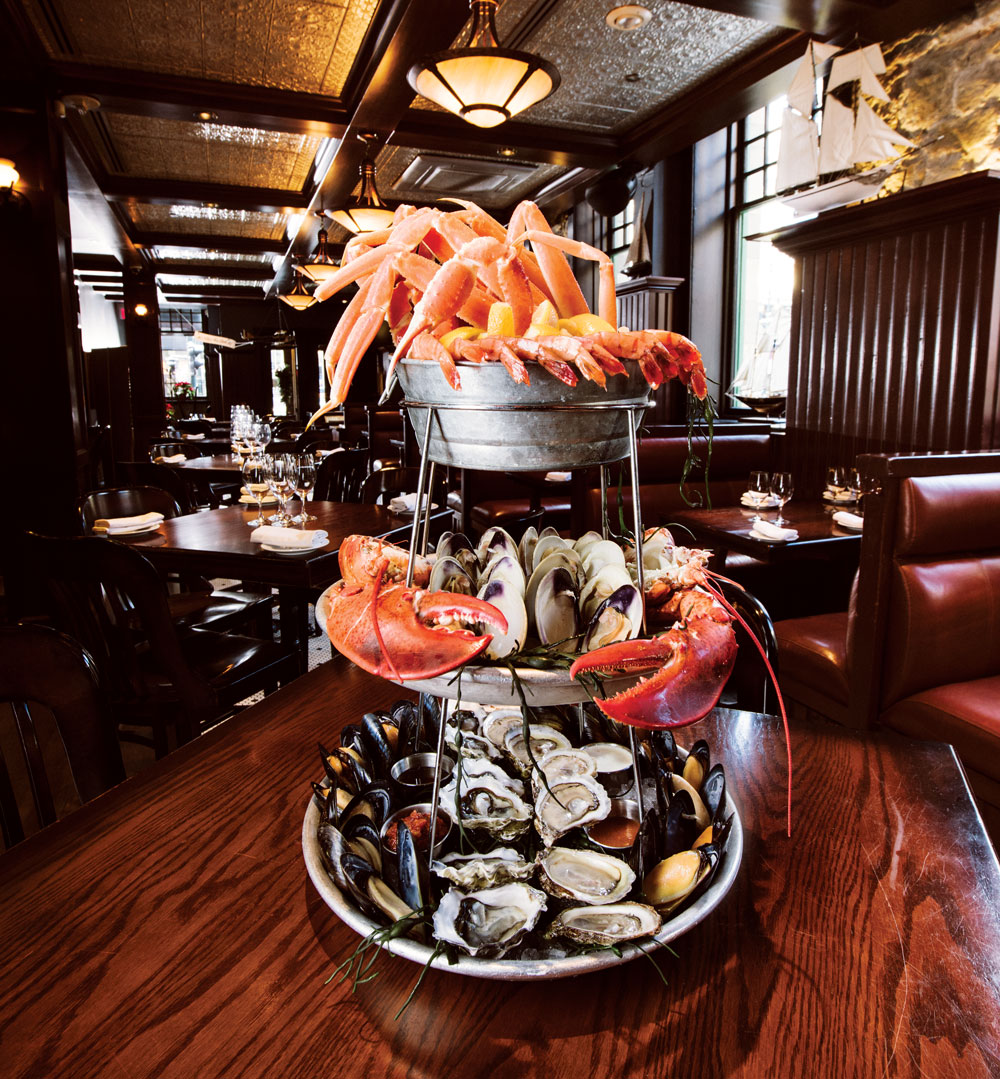 Catch signature chilled seafood tower with lobster, crab clusters, oysters, clams, mussels, peel-and-eat shrimp, and cocktail and tartar sauce.