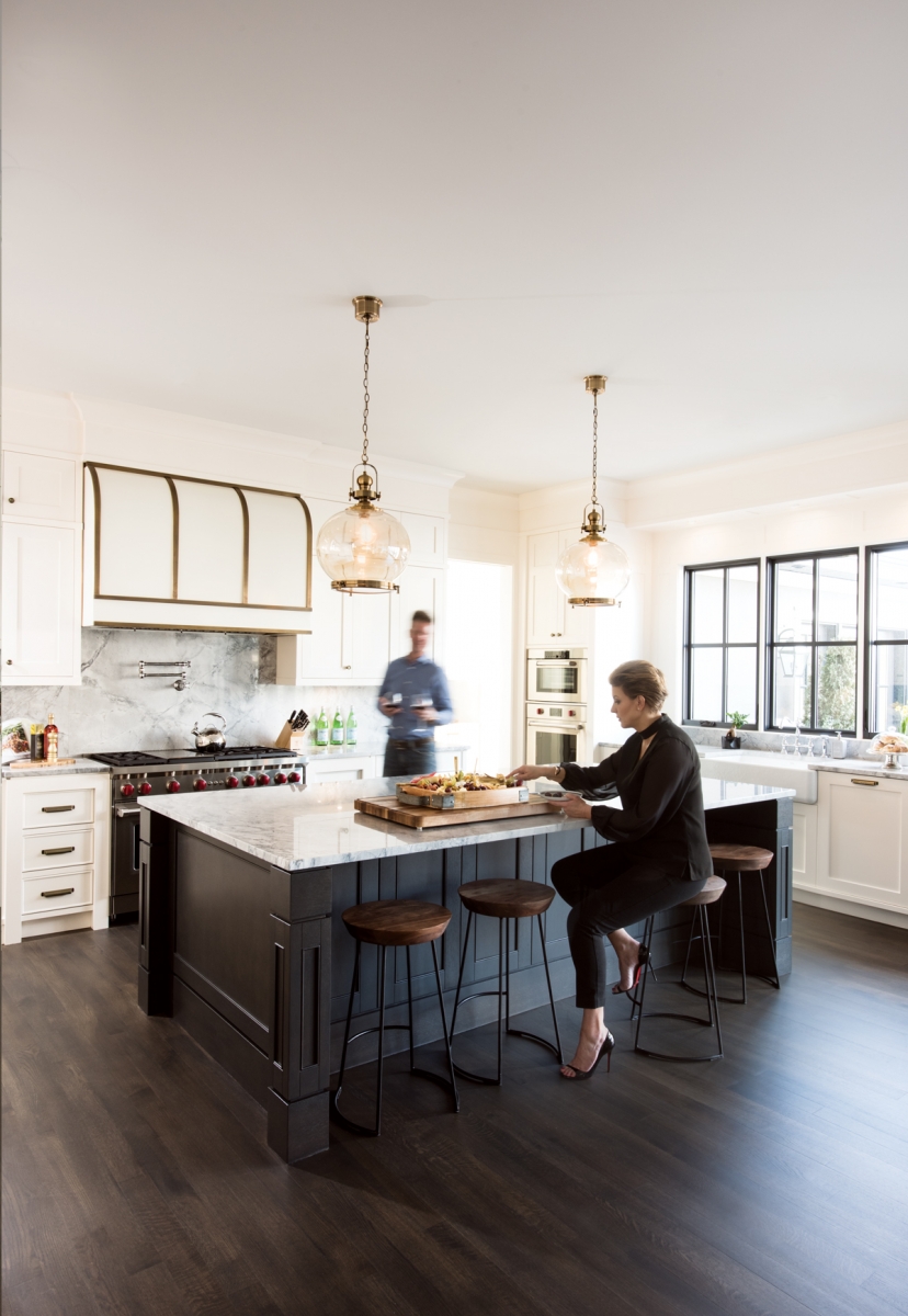 Homeowners Joanna Januszewska and Rafal Wieczorek in the kitchen of their home in Roxboro. The five-by-10-foot kitchen island is stained in a custom-created colour called Charcoal Mist, which was used throughout the home.Â