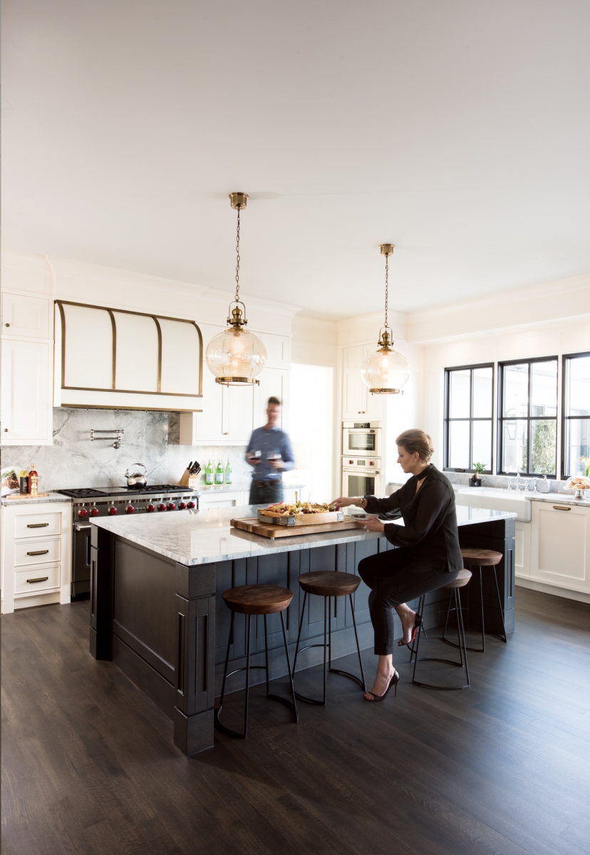 Homeowners Joanna Januszewska and Rafal Wieczorek in the kitchen of their home in Roxboro. The five-by-10-foot kitchen island is stained in a custom-created colour called Charcoal Mist, which was used throughout the home. 