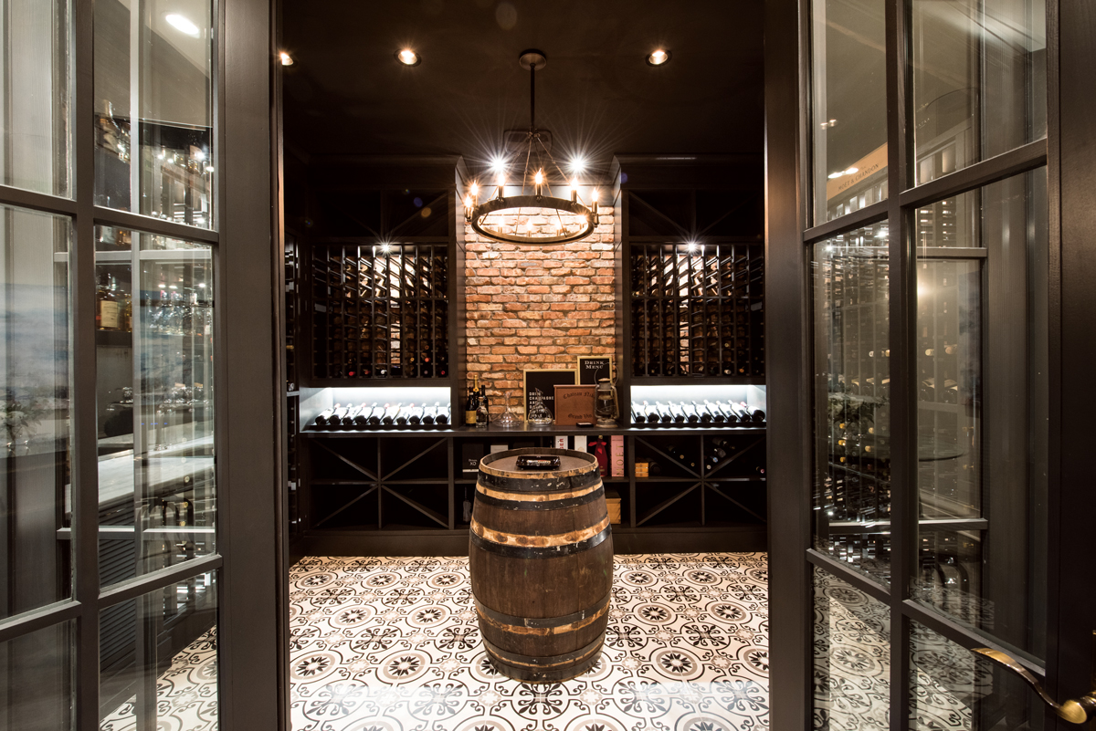 Perfect for holding tastings or smoking a cigar, the wine cellar/cigar room suggests an Old World European tavern with its tiled floor, cherry-wood shelving and a wine barrel imported from Italy used as a table.