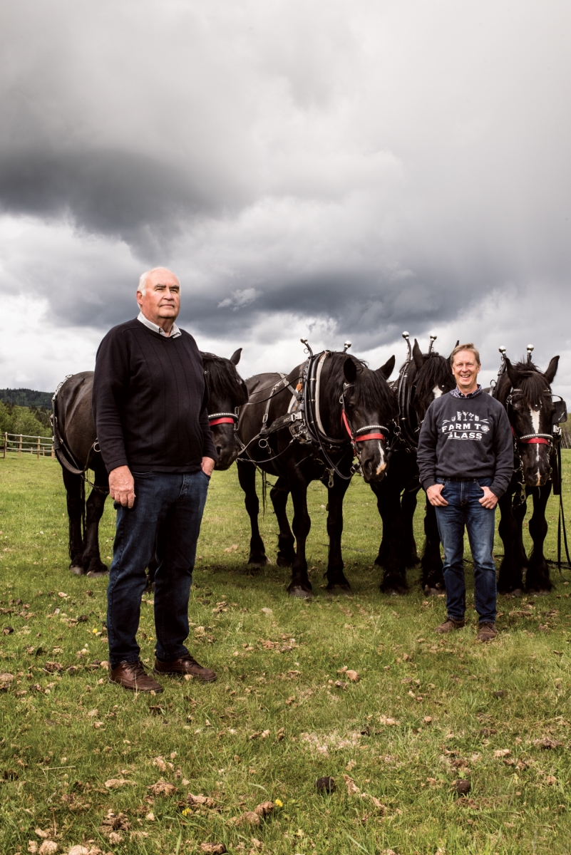 Eau Claire Distillery master distiller Larry Kerwin (left) and president and co-founder David Farran (right) with horses used in traditional farming practices to produce grains that are distilled into Eau Claire spirits. 