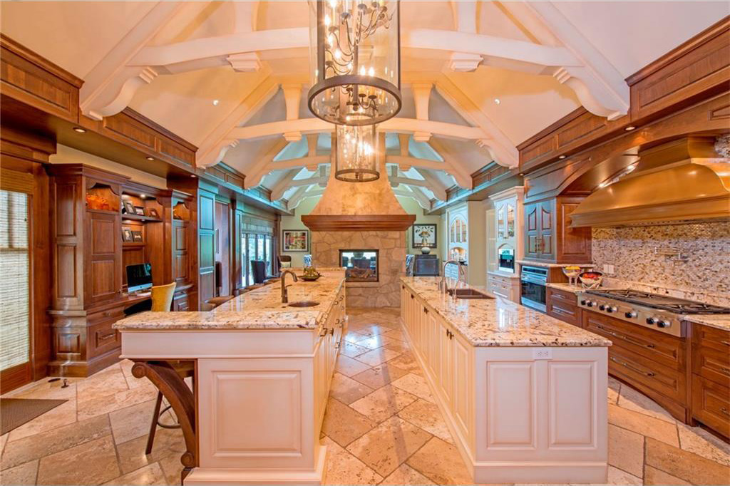 The kitchen has two islands, a sandstone fireplace, raised panel walnut cabinetry and a gas range. It also has two dishwashers.