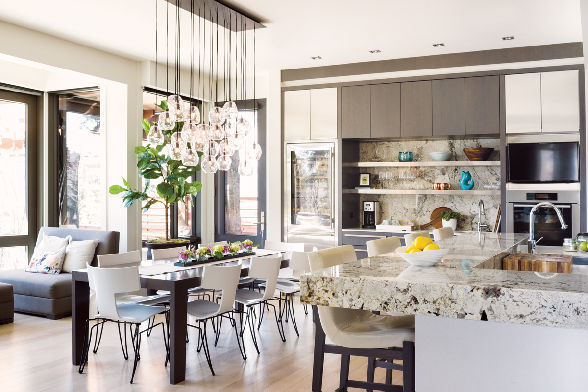 The John Pomp Studios hand-blown glass chandelier hangs over the custom Red Eight Workshop dining table, designed to match the home’s millwork.