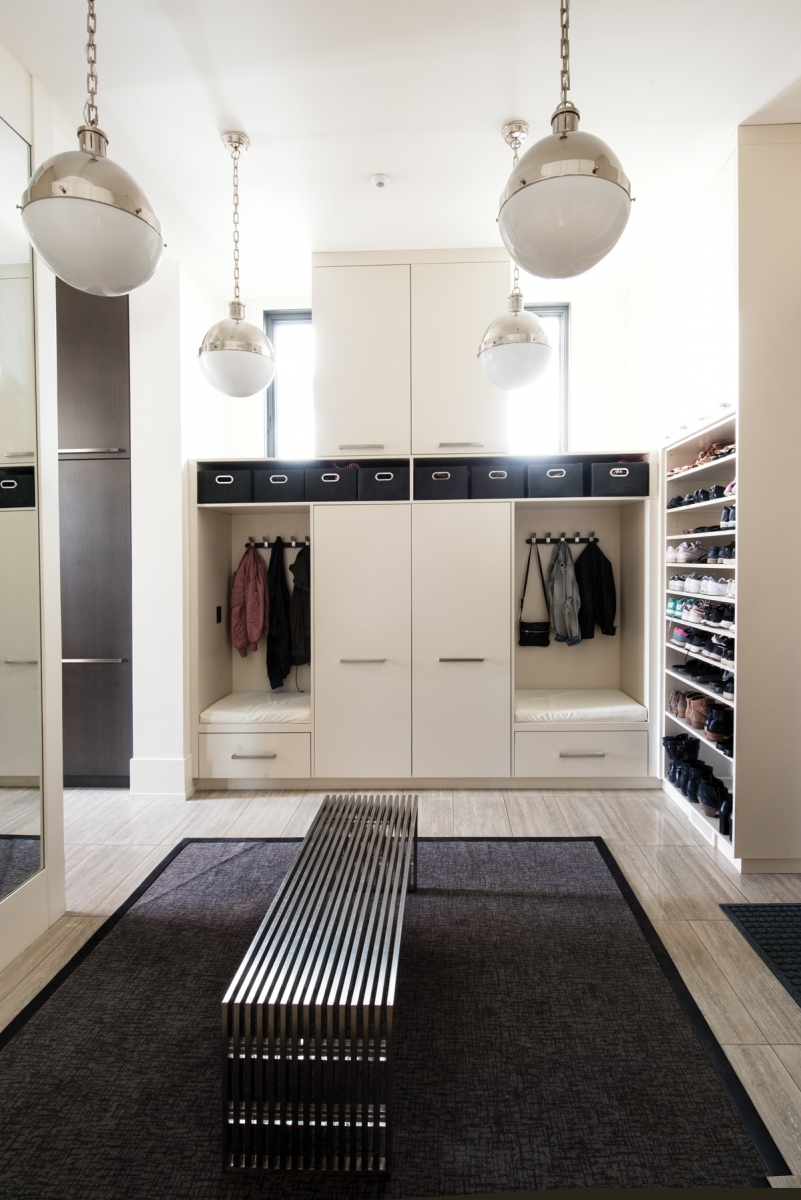 The mud room is airy and bright with Hicks pendant lighting and ample storage.