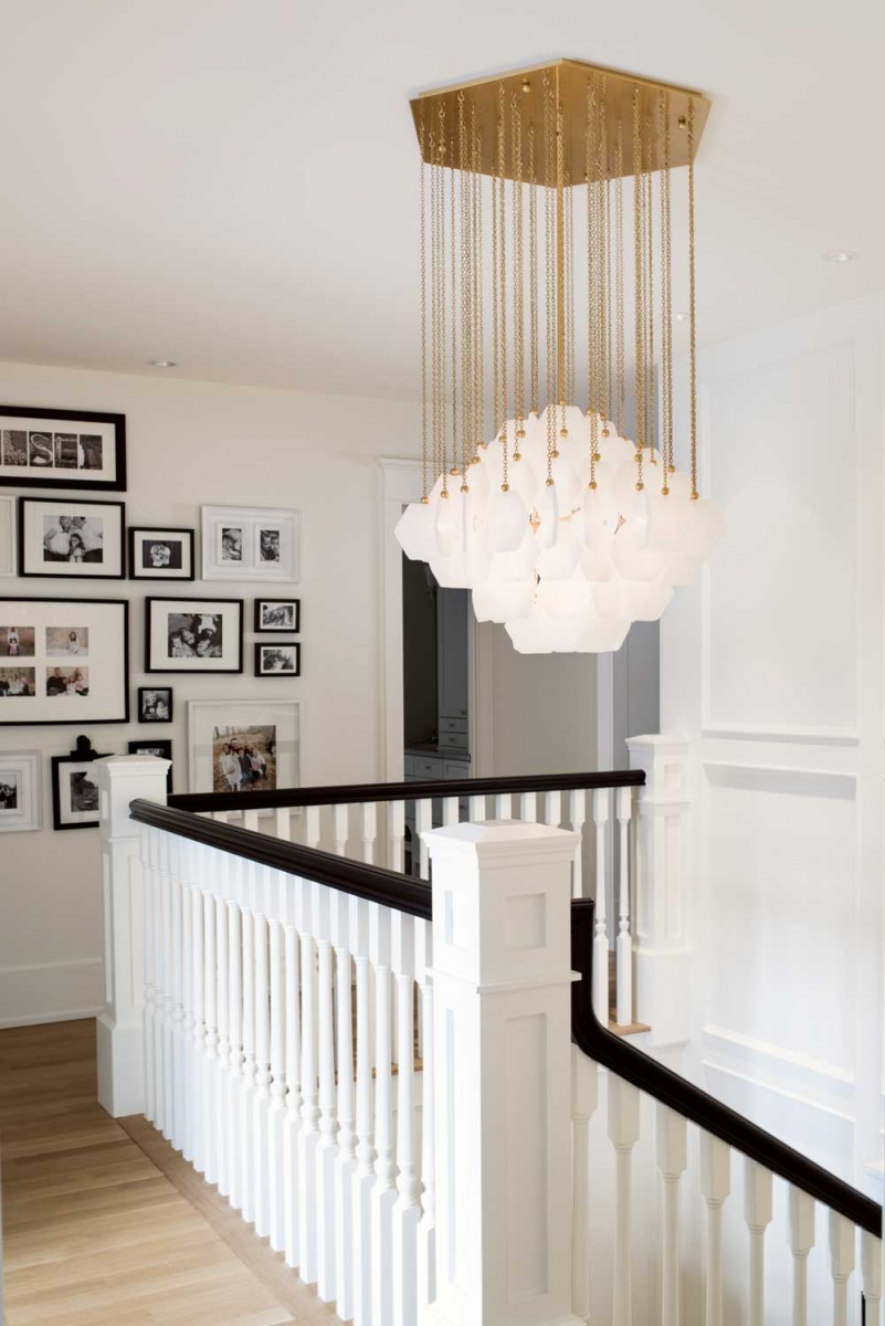 An eye-catching Jonathan Adler chandelier hung above the main staircase adds a touch of glamour to the upper hallway area.