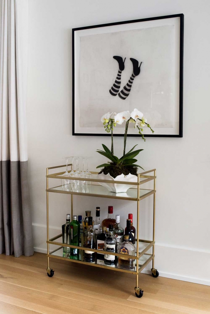 A bar cart and artwork by Cathy Daley add even more personality to the living room area.